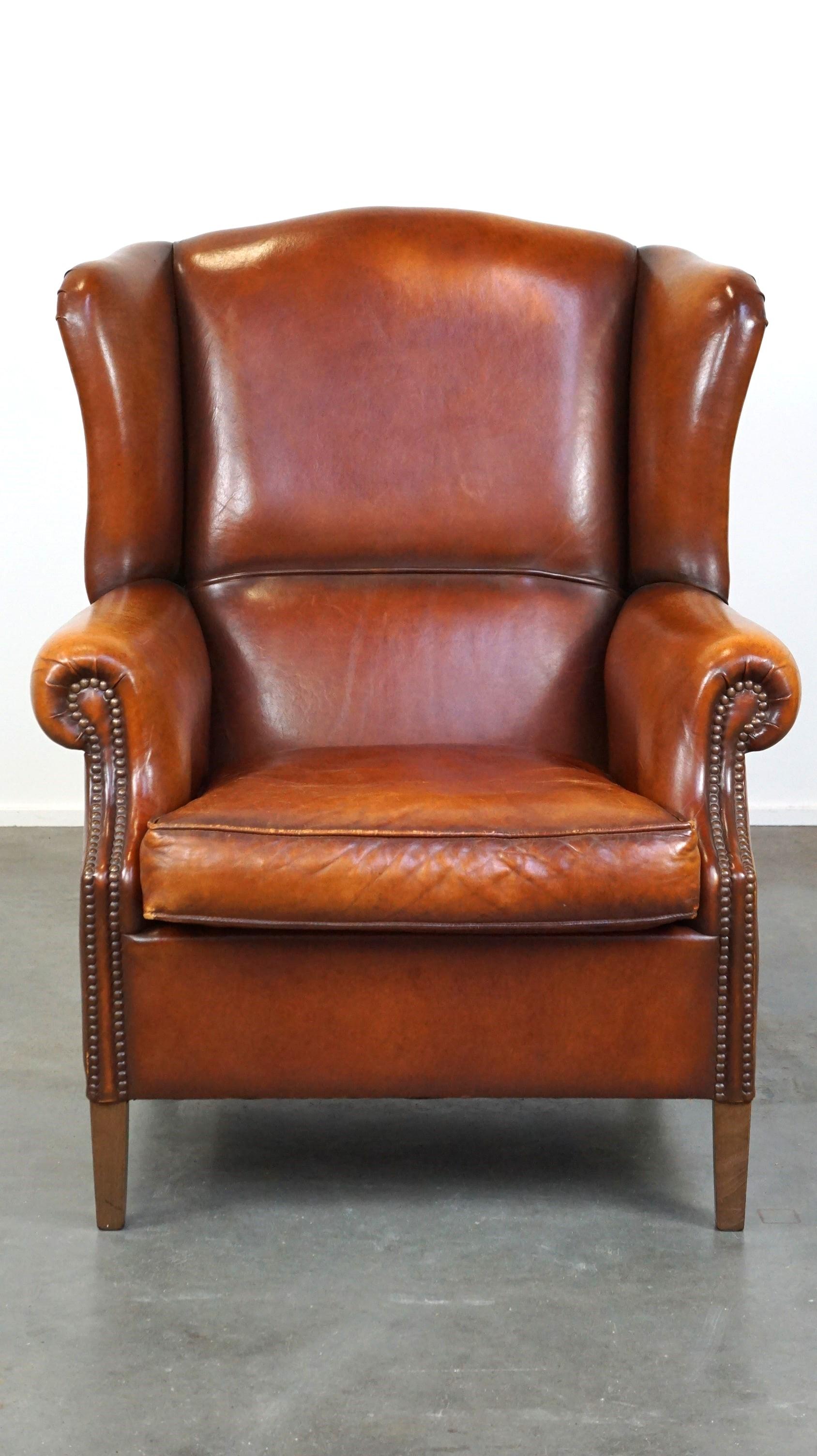 Ce magnifique fauteuil à oreilles est fabriqué en peau de mouton et a un aspect chaleureux grâce à ses jolies couleurs. Il peut être facilement placé dans les intérieurs classiques et modernes et il est très confortable de s'y asseoir. Il est doté