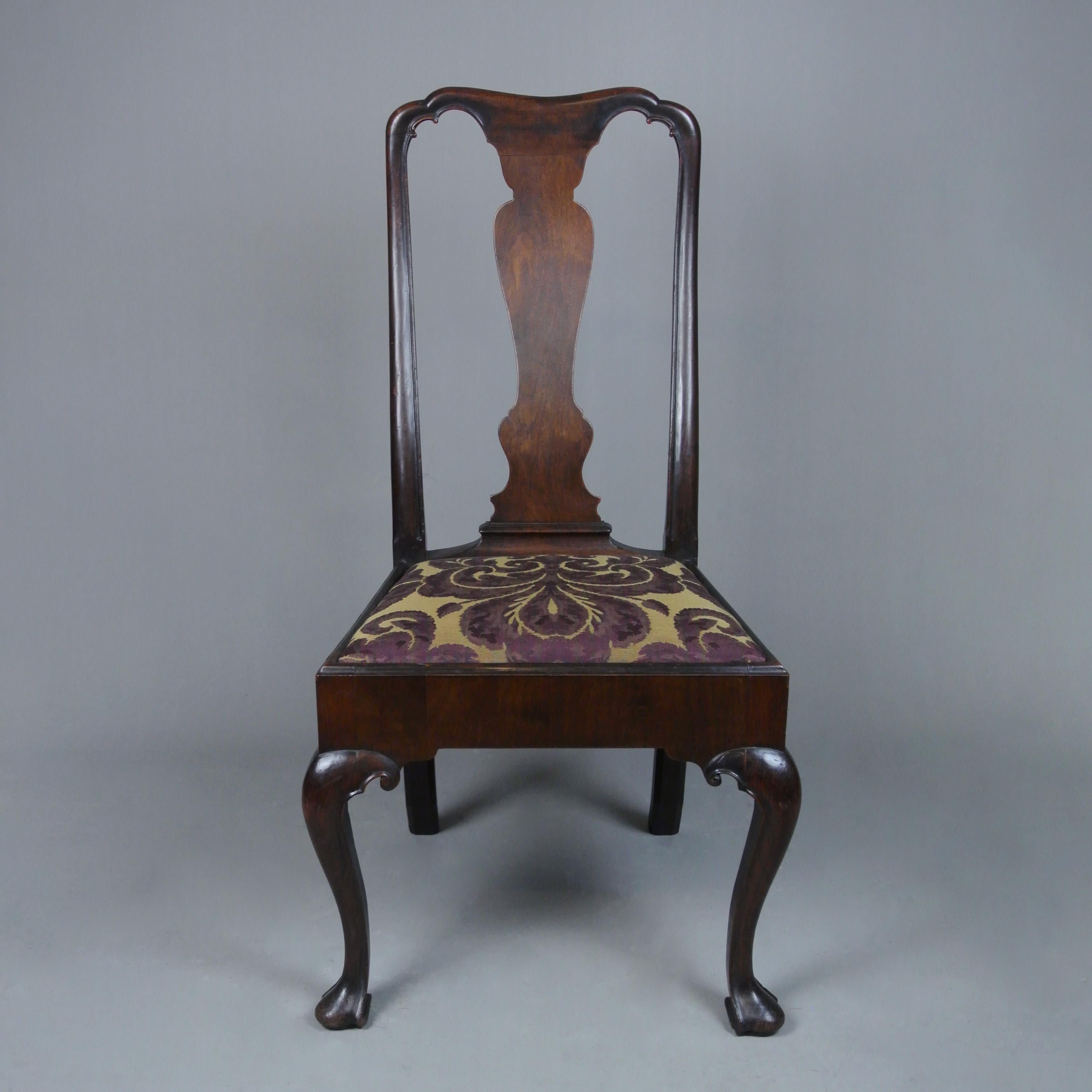 A very beautiful early Georgian chair in excellent original condition and very finely detailed in solid walnut.

The square seated thickly veneered in walnut and with arched well shaped splat. Small scrolls carved at the ears of the solid walnut
