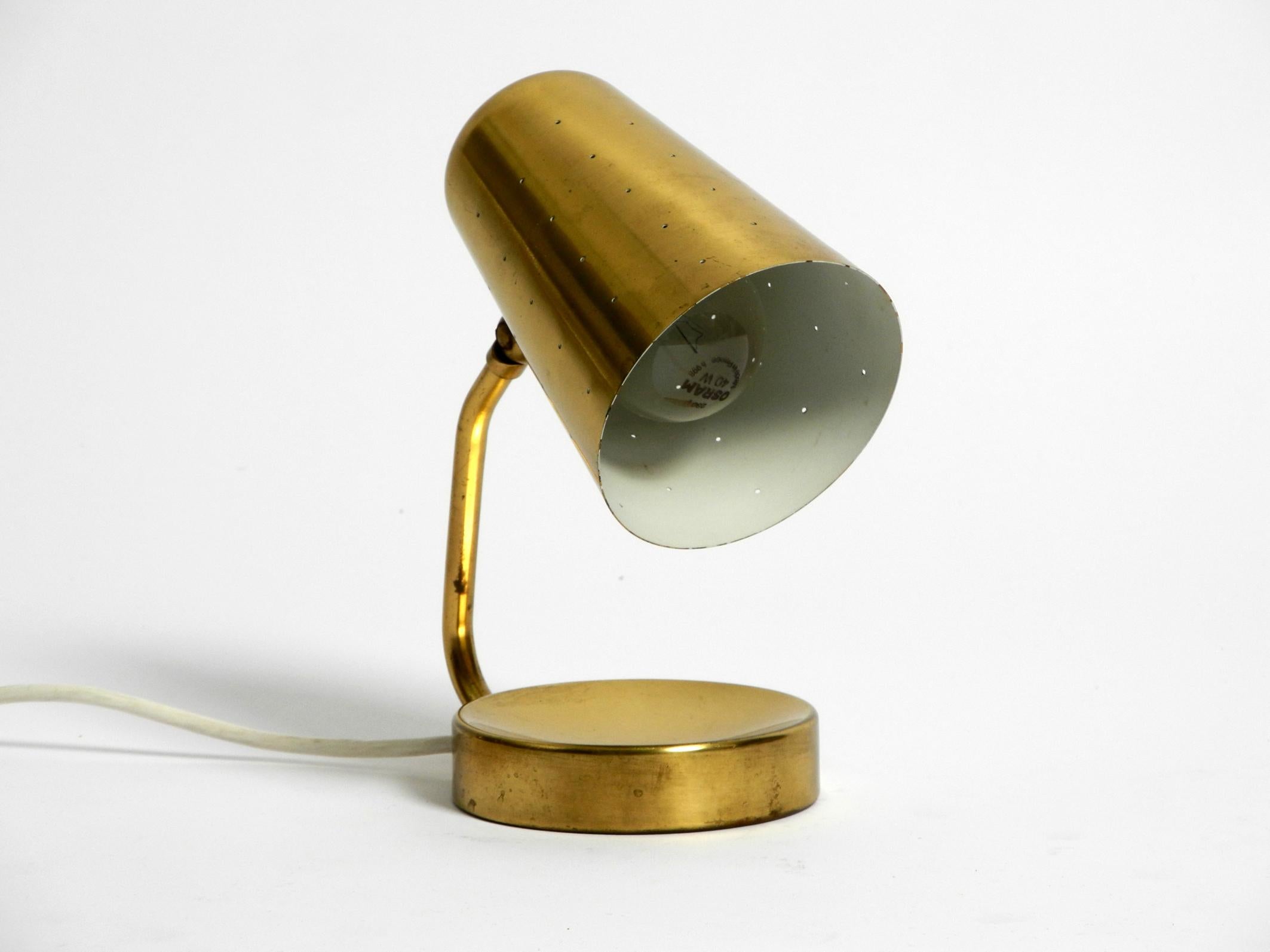 Beautiful large Mid-Century Modern brass table lamp.
The shade is steplessly adjustable. Very classy 1950s design.
The lampshade has small holes, which looks great with the light shining through, like little stars.
In a good vintage condition. No