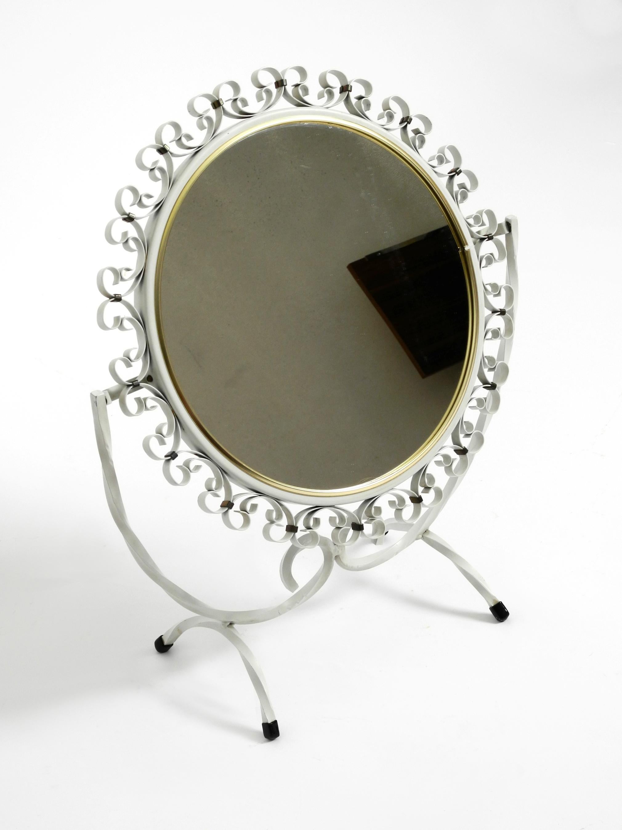 Beautiful movable midcentury metal table mirror in white. 
Rare design. Made in Germany.
Frame is made entirely of metal. Solid and heavily built. 
Very good condition without damages. No scratches on the mirror glass.
Frame is with a very light