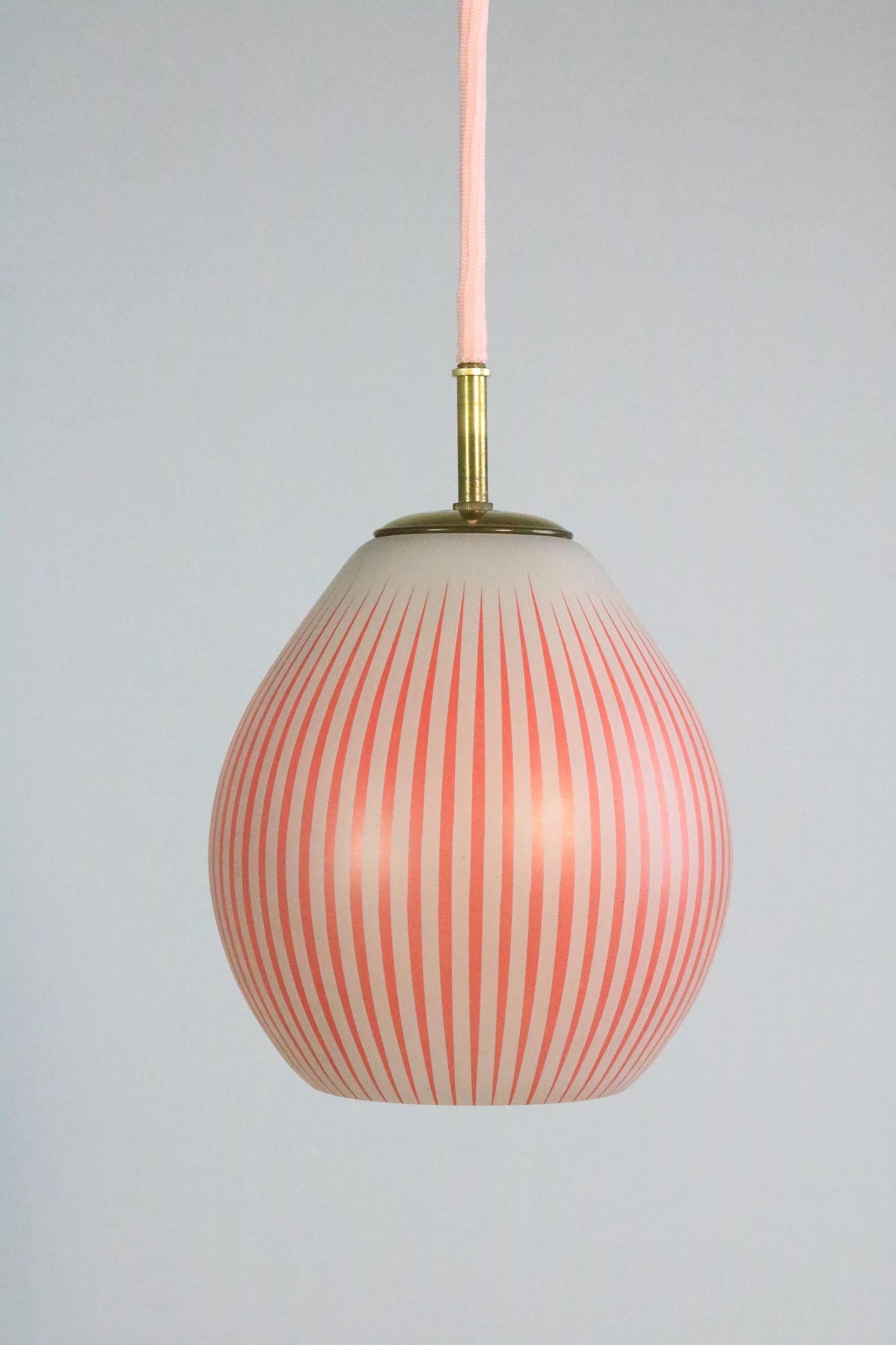 Red and White striped glass lamp. Newly wired with pink colored textile cable. Beautiful brass finish and brass canopy.
The white lamp in matching design you will find in another offer.

Minimal unevenness on the edge of the glass.

Glass height: 20