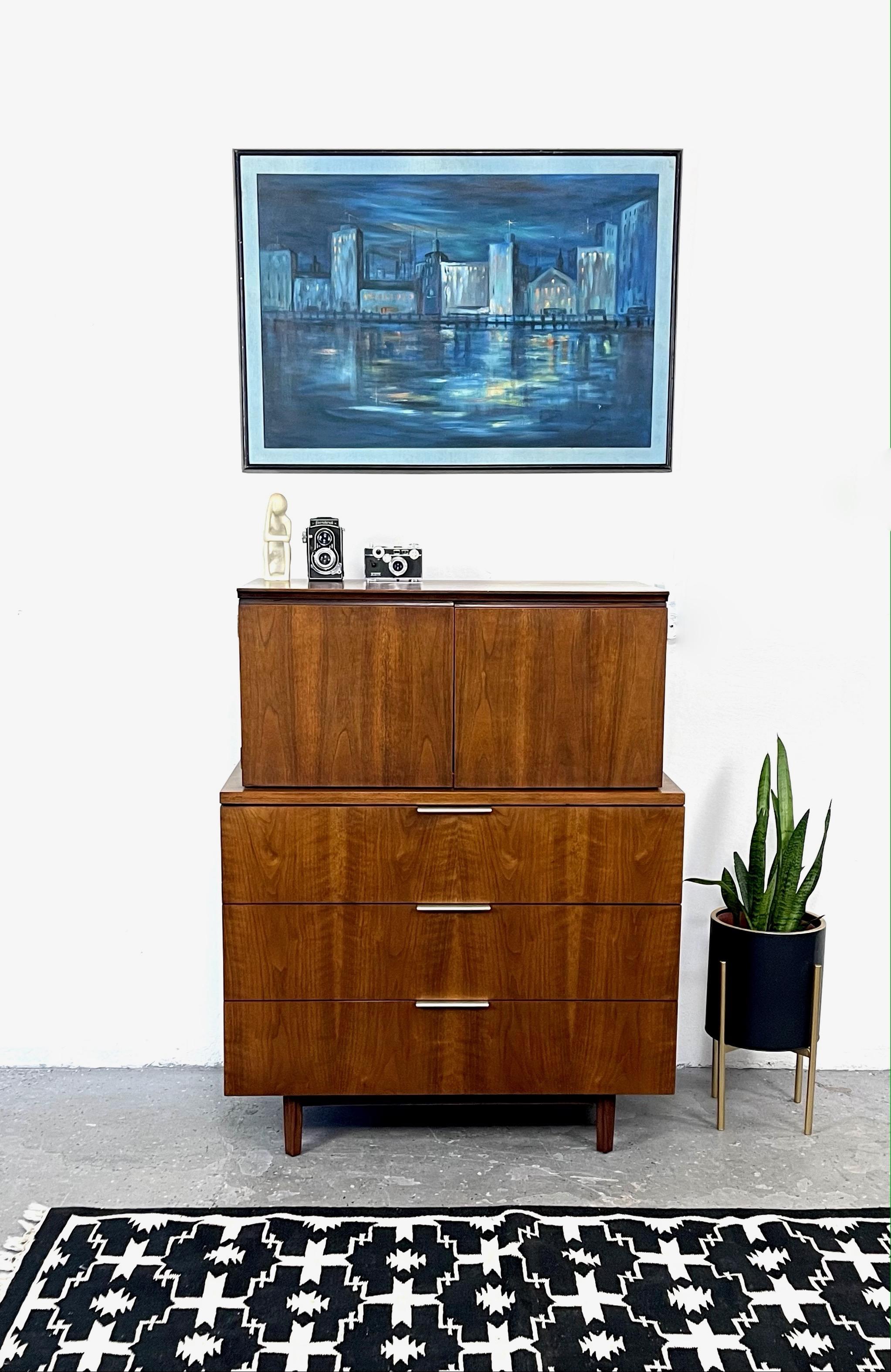 Wow all original finish and in amazing condition. Mid-Century Modern highboy dresser designed by John Stuart for Johnson Furniture Co. in the United States, circa 1960s. Pure style and sophistication, featuring three spacious long drawers on the