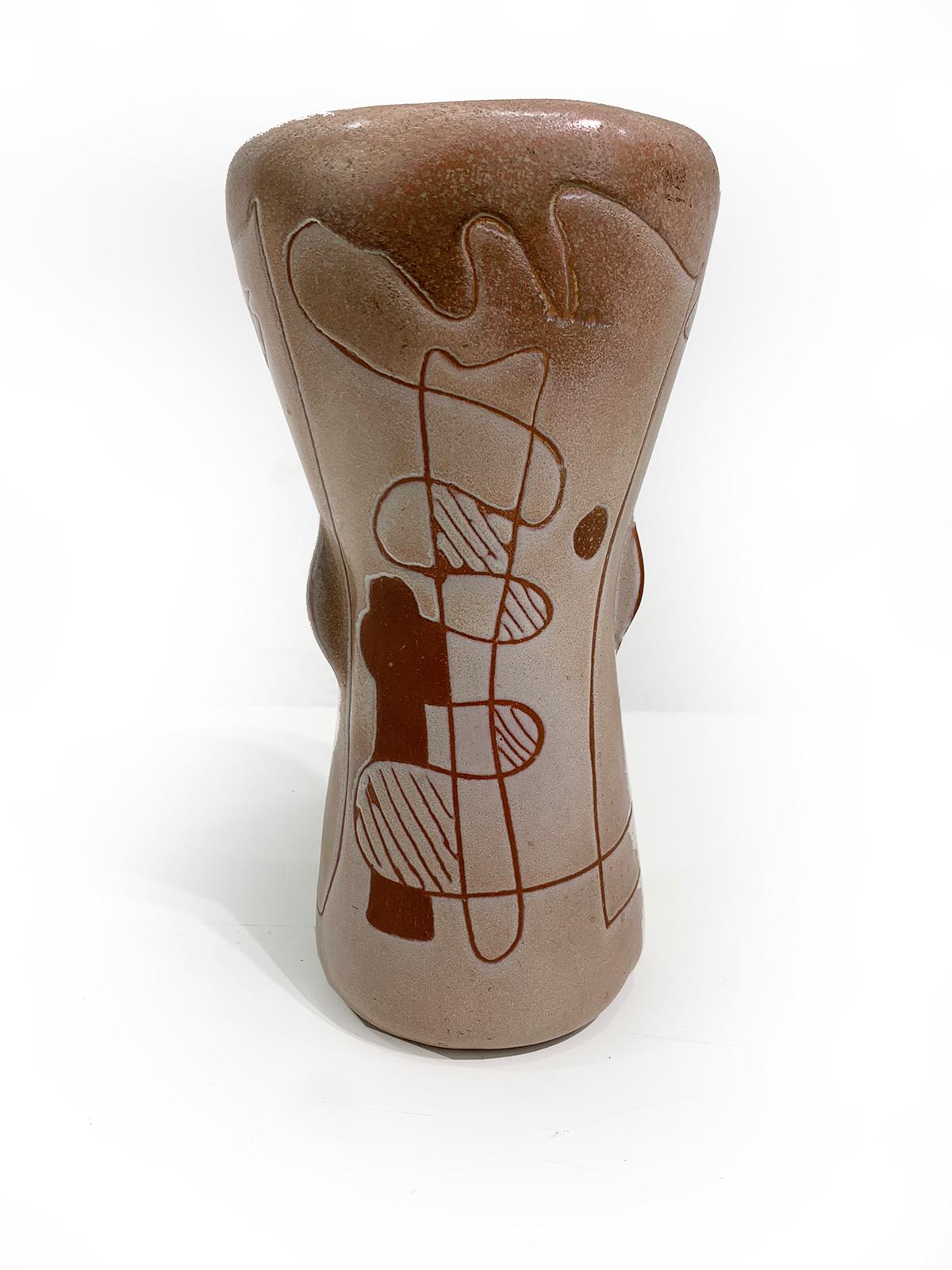 Unique Mid-century ceramic vase, with abstract design and earth colors giving it a rich vintage appeal,  having the signature of the artist on the underside, circa 1960.
