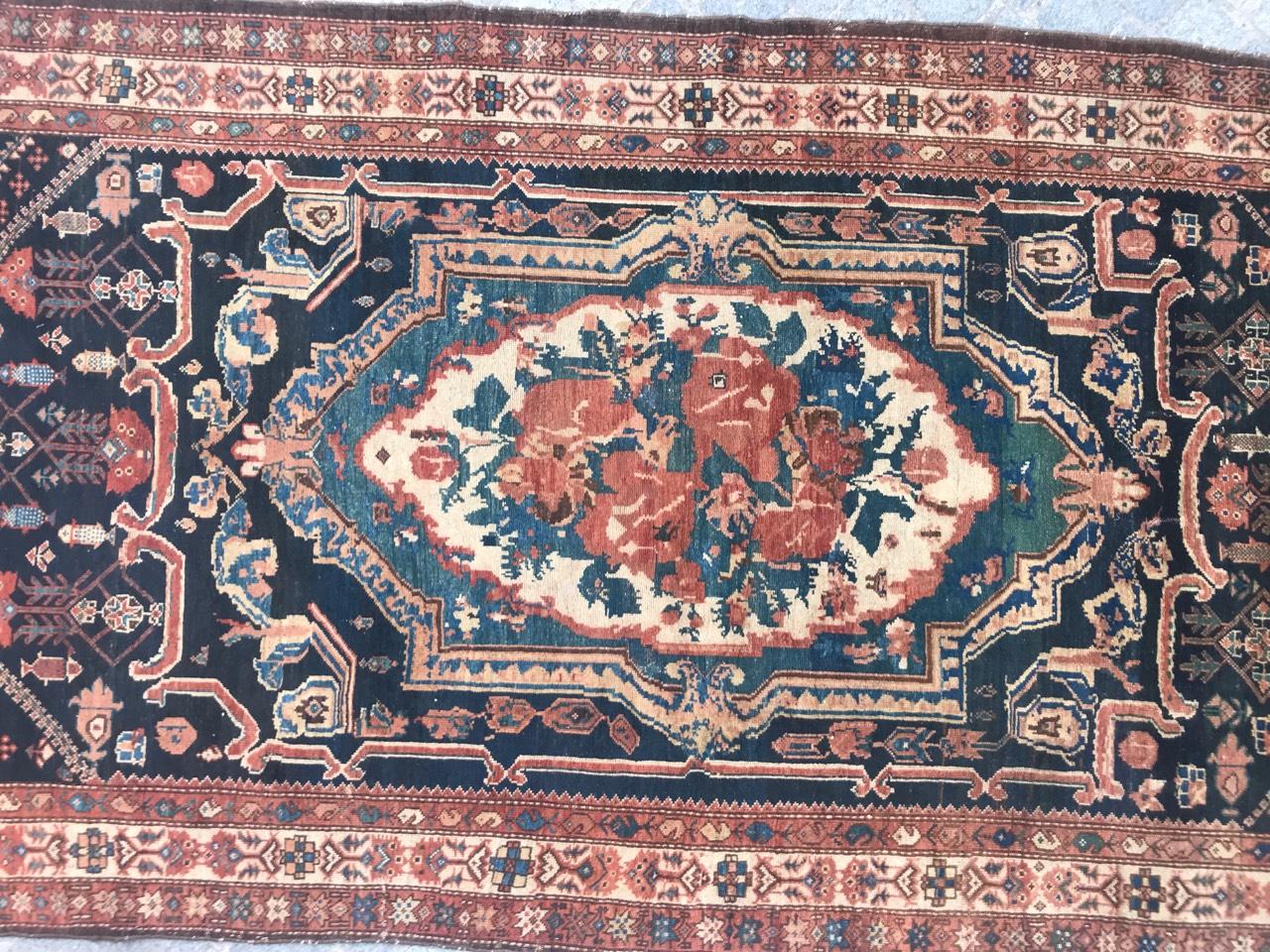 Découvrez l'élégance intemporelle de notre exquis tapis Bakhtiar de la fin du XIXe siècle. Orné d'un captivant médaillon central au motif floral de la Savonnerie, de motifs tribaux et d'une riche palette d'orange, de bleu, de vert, de rose et de