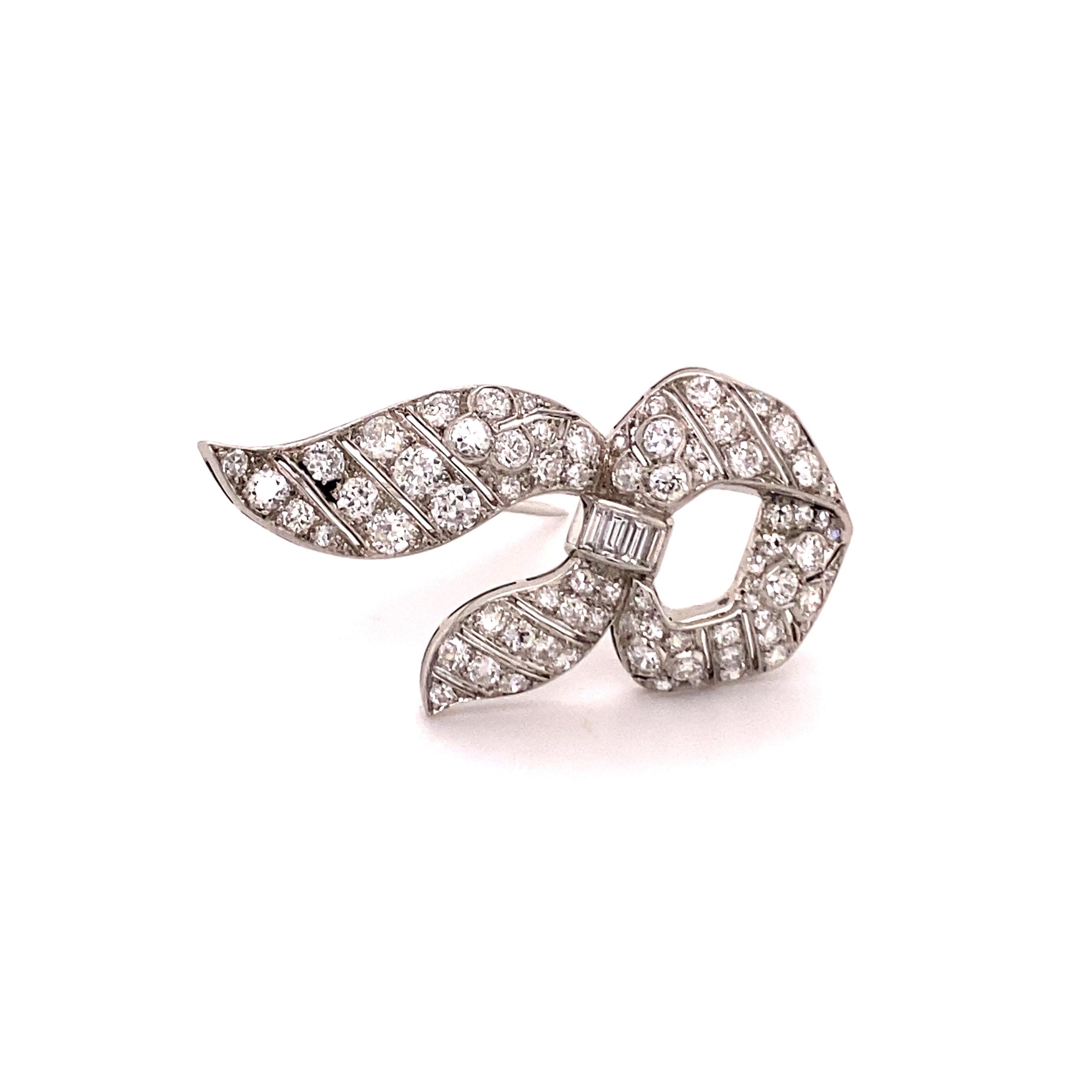 This beautiful brooch from the 1950s features approximate 2.10 carats of round brilliant- and baguette-cut diamonds set in a ribbon design. 

À jour worked - made in platinum. A very charming piece.

Dimensions: 42 x 20 mm / 1.65 x 0.79 inches
Assay