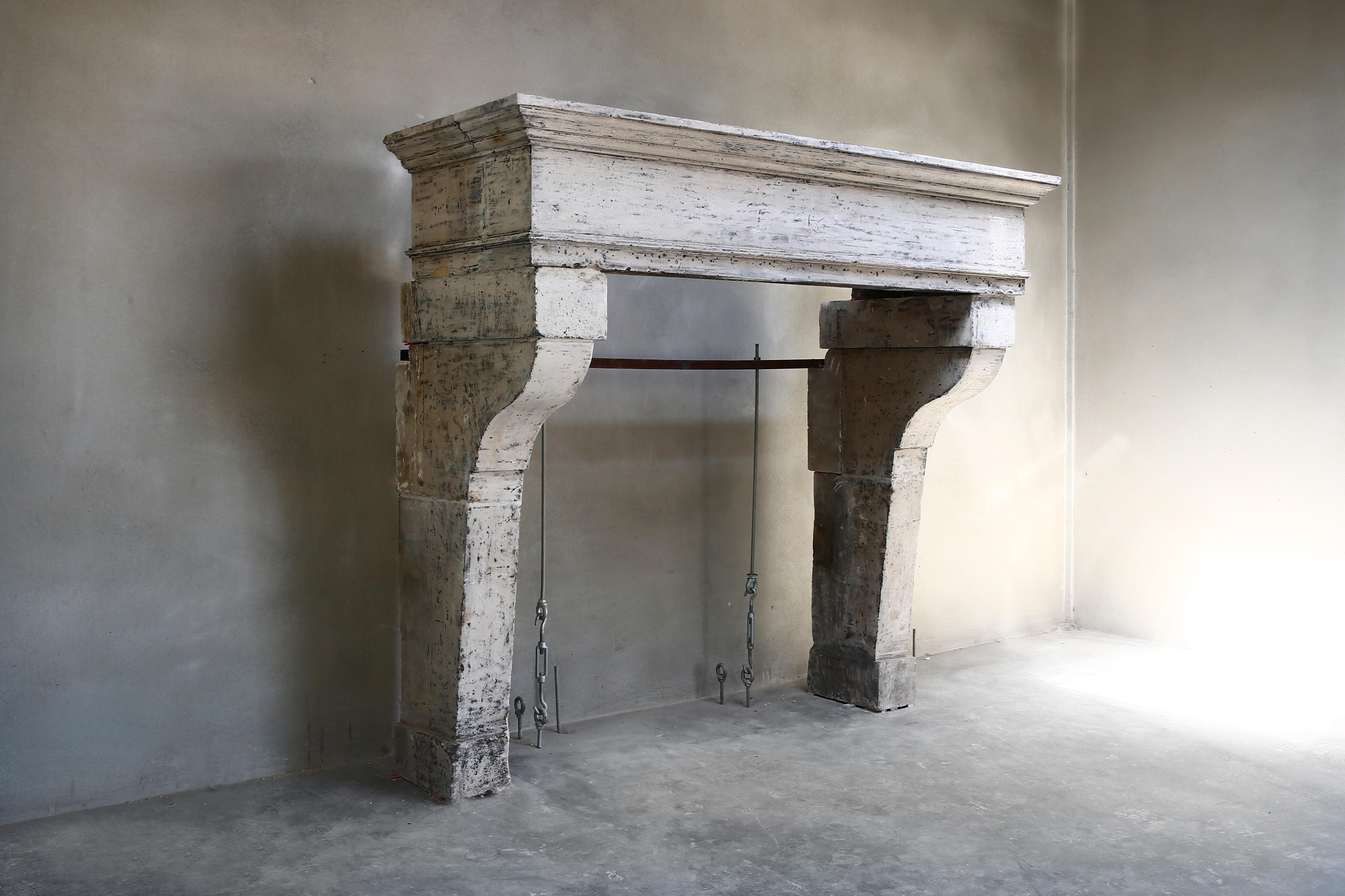 Beautiful antique castle fireplace with a beautiful patina. This French limestone fireplace dates from the 19th century and is in Campagnarde style. The top has beautiful lines so that the robustness of the fireplace comes out well. An antique
