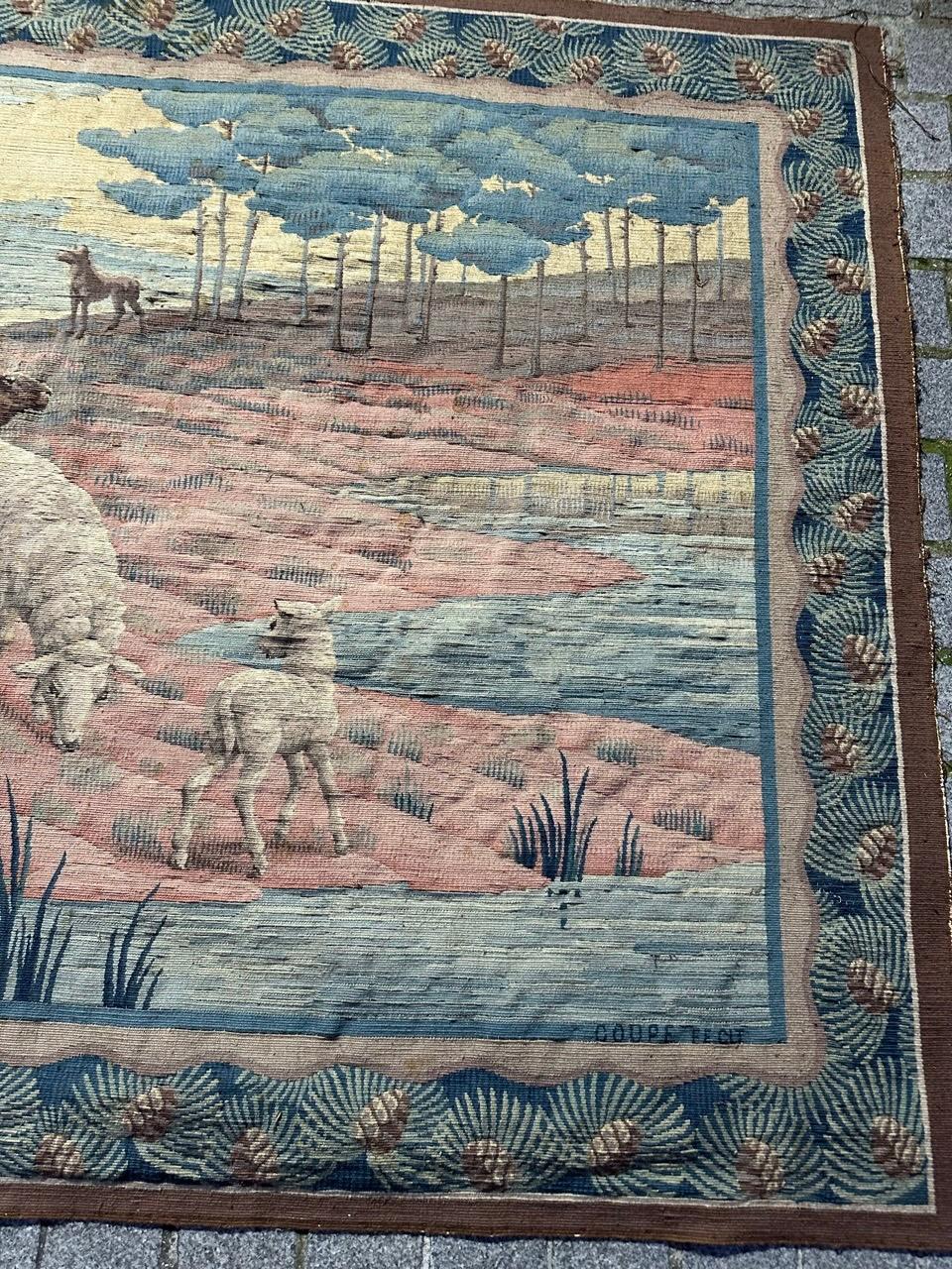 Discover the timeless elegance of this early 20th-century Aubusson or Flanders tapestry featuring a captivating design of a shepherd with sheep.

This tapestry depicts a pastoral scene in soft, muted tones. At the center stands a shepherd holding a