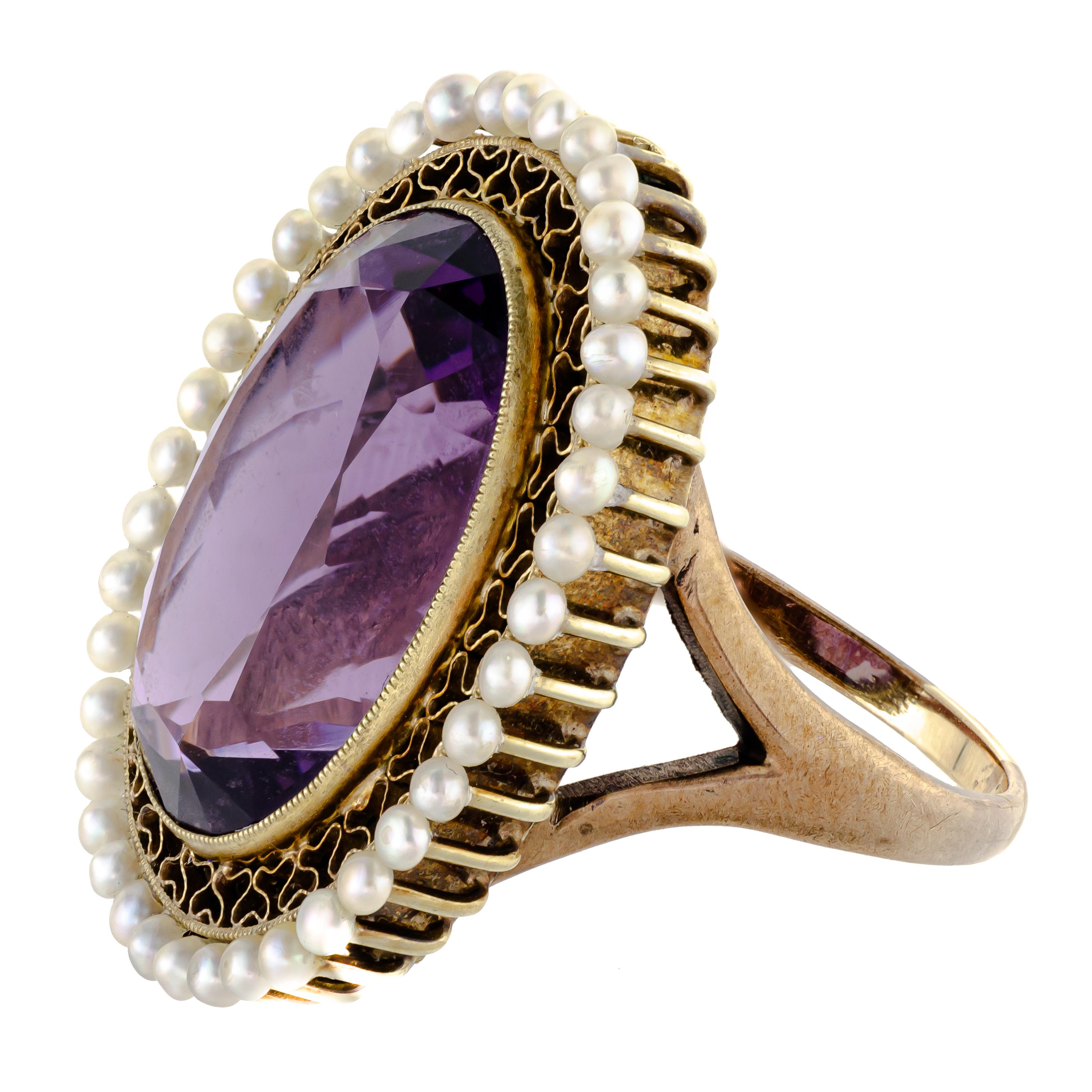 Absolutely beautiful antique impressive size amethyst pearl and 14kt yellow gold ring centrally set with one large oval shaped faceted deep vibrant purple amethyst measuring approximately 19 x 14 x 9.5mm depth with an approximate weight of 13.40