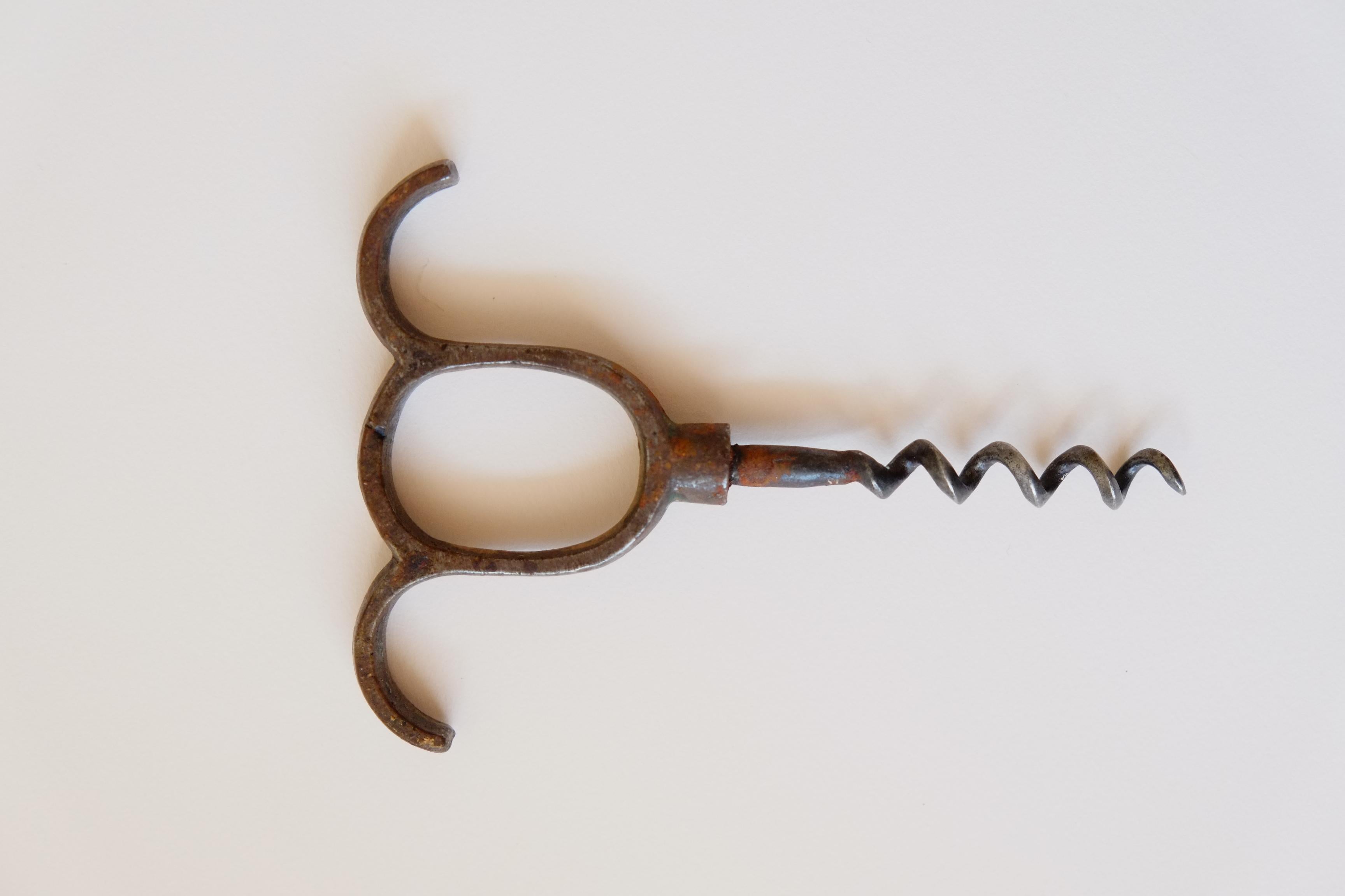 A beautiful cast iron antique corkscrew. From the late 19th or early 20th century - the simplest finger pull design makes for a timeless piece. The perfect addition to any bar. This corkscrew  would have been originally gilt, as there is some