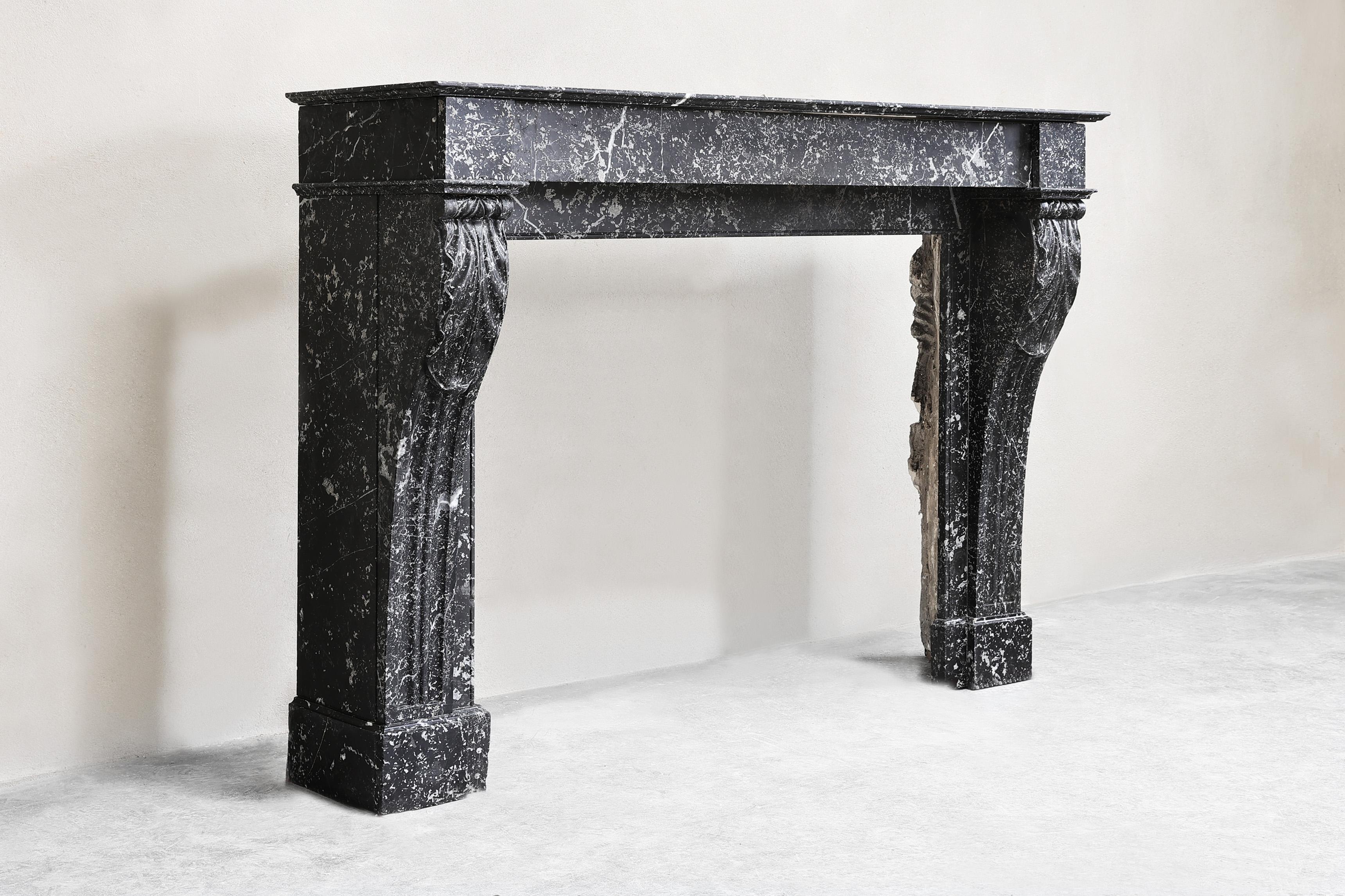 Beautiful antique mantelpiece made of black marble with white veins in the style of Louis XVI from the 19th century! This beautiful, sleek mantle has slightly curved legs and a warm appearance! A beautiful fireplace with an accessible size.