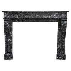 Beautiful antique mantelpiece made of black marble with white veins in the style