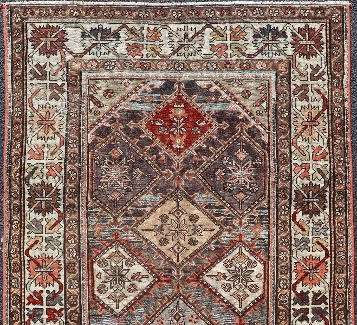 antique Bakhtiari rug in Geometric motifs and diamond design in the background. the background is composed of light and medium gray, red, green, yellow, salmon, cream , lavender in steel blue and lavender color tones, rug SUS-2012-693, origin /