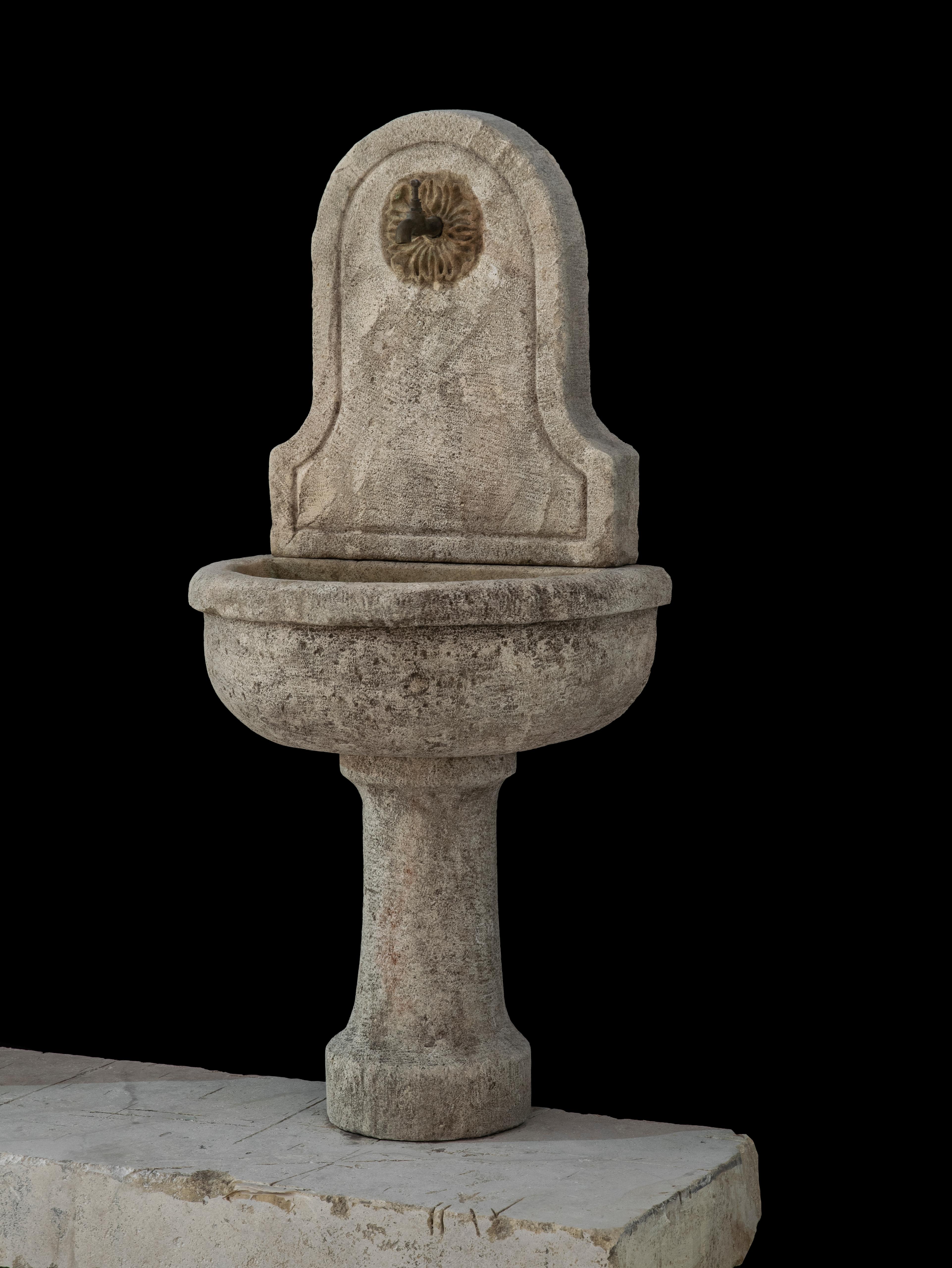 This beautiful antique 19th century limestone wall fountain is a great addition to any Mediterranean, Tuscan, rustic, or other custom style home. The naturally aged color and distressed patina for this old reclaimed hand-carved French fountain adds