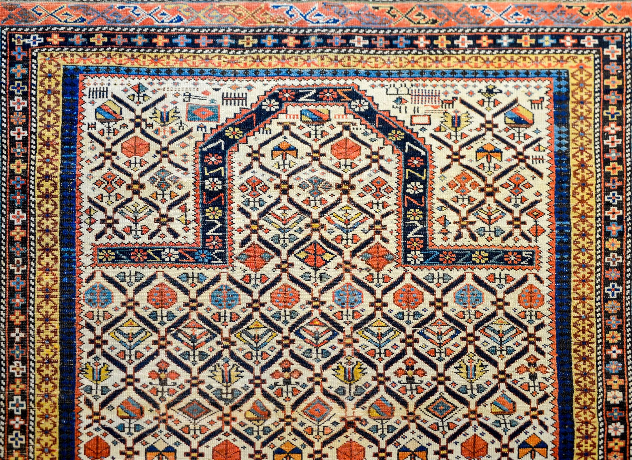 A beautiful late 19th century antique Persian Shirvan prayer rug with an incredible stylized multicolored floral pattern field and woven with in crimson, indigo, white, gold, indigo, and brown natural vegetable dyed wool on a white background. The