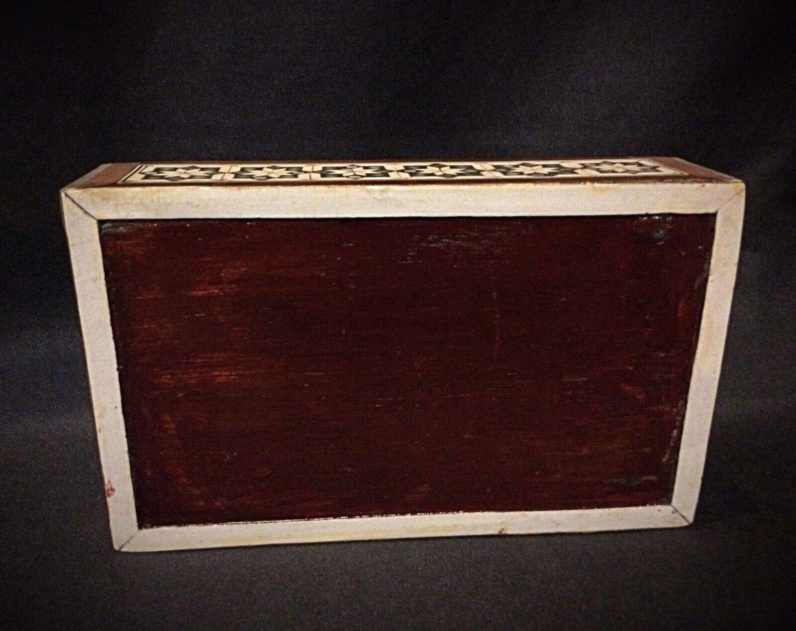 Questo squisito antico portagioie siriano del XX secolo presenta un'intricata lavorazione del legno e intarsi in madreperla. Il design elegante è completato da un ricco interno in velluto rosso, che lo rende un'aggiunta straordinaria a qualsiasi