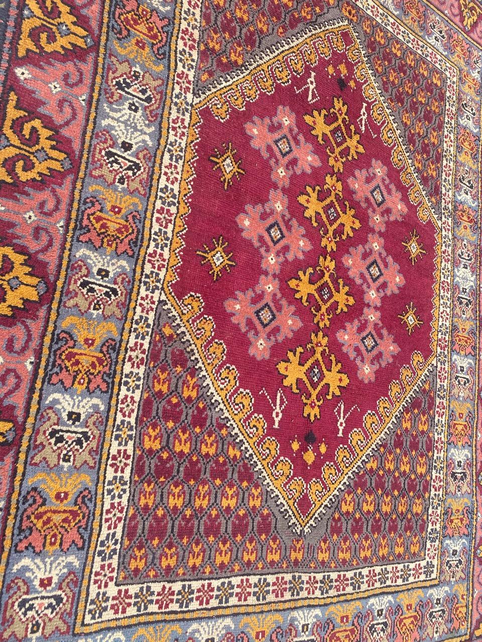 Nice vintage rug from Tunisia, with geometric designs and pretty colors, with pink, purple, orange and yellow, entirely hand-knotted with wool velvet on cotton foundation.