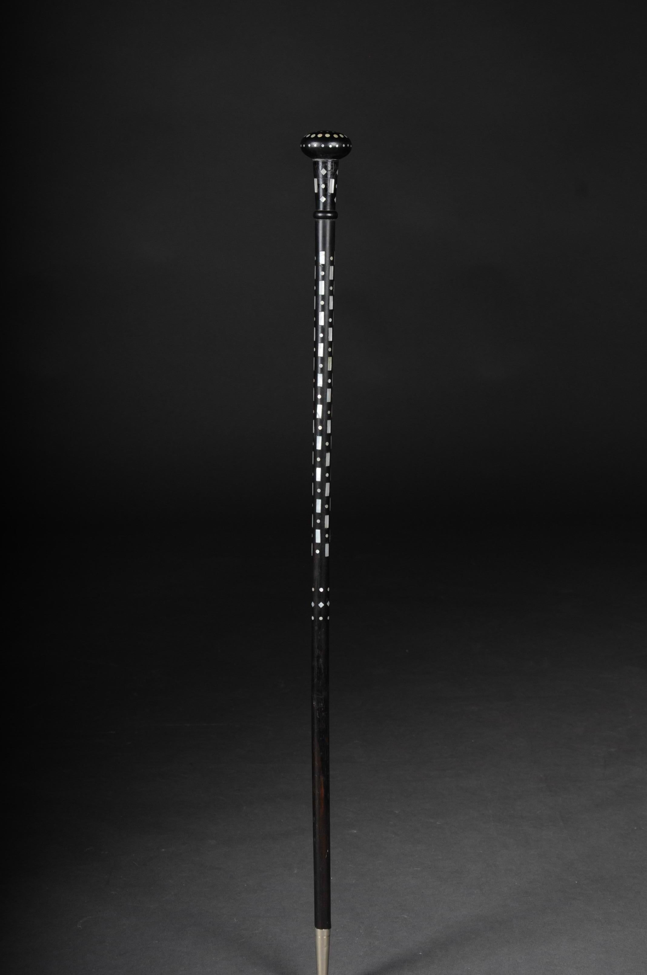 Exceptional walking stick with geometrically inlaid mother-of-pearl. Mother-of-pearl distributed in symmetrical intervals. Stick end with silver-colored spout. Stick handle in the form of a knob. Very fine handwork.

(V-182).



 