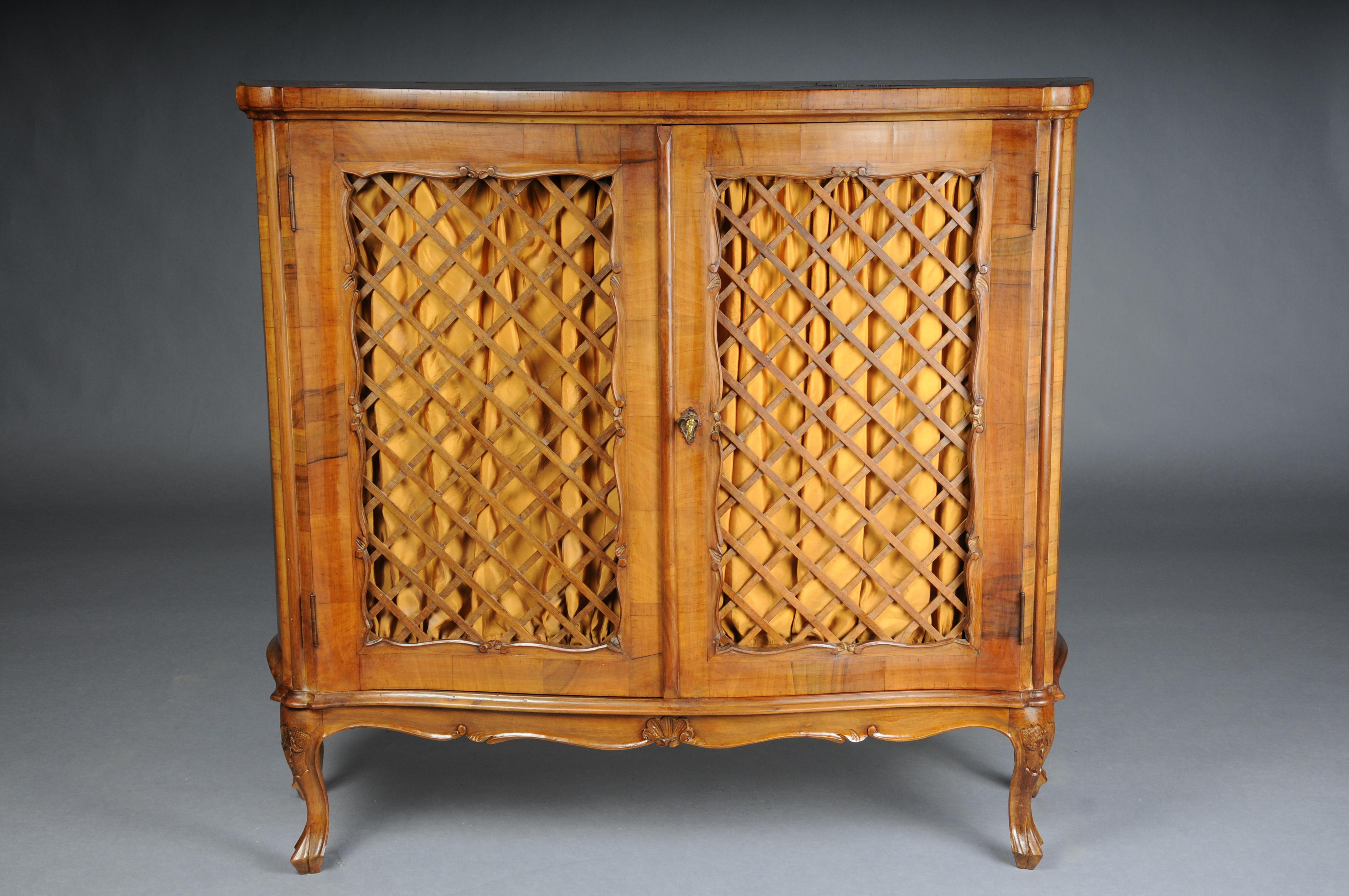 Beautiful antique wall cabinet/hall cabinet, 20th century. Walnut root veneer.
 
Solid wood with walnut root veneer and inlays. Hall cabinet made of solid wood, baroque. Multi-curved body standing on high curved legs. Two-door with lattice fence
