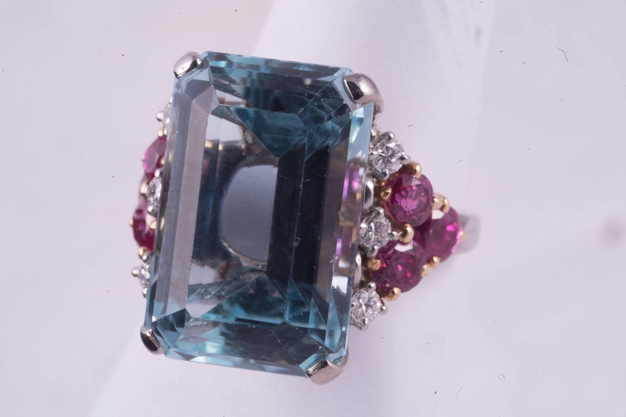 Approx. 13.00cts rectangular cut medium to light blue Aquamarine. There are 6 round cut rubies, 3 on each side of the ring that weigh a total of approx. 1.20cts. There are 3 diamonds on either side of the aqua that weigh approx. .30cts total.