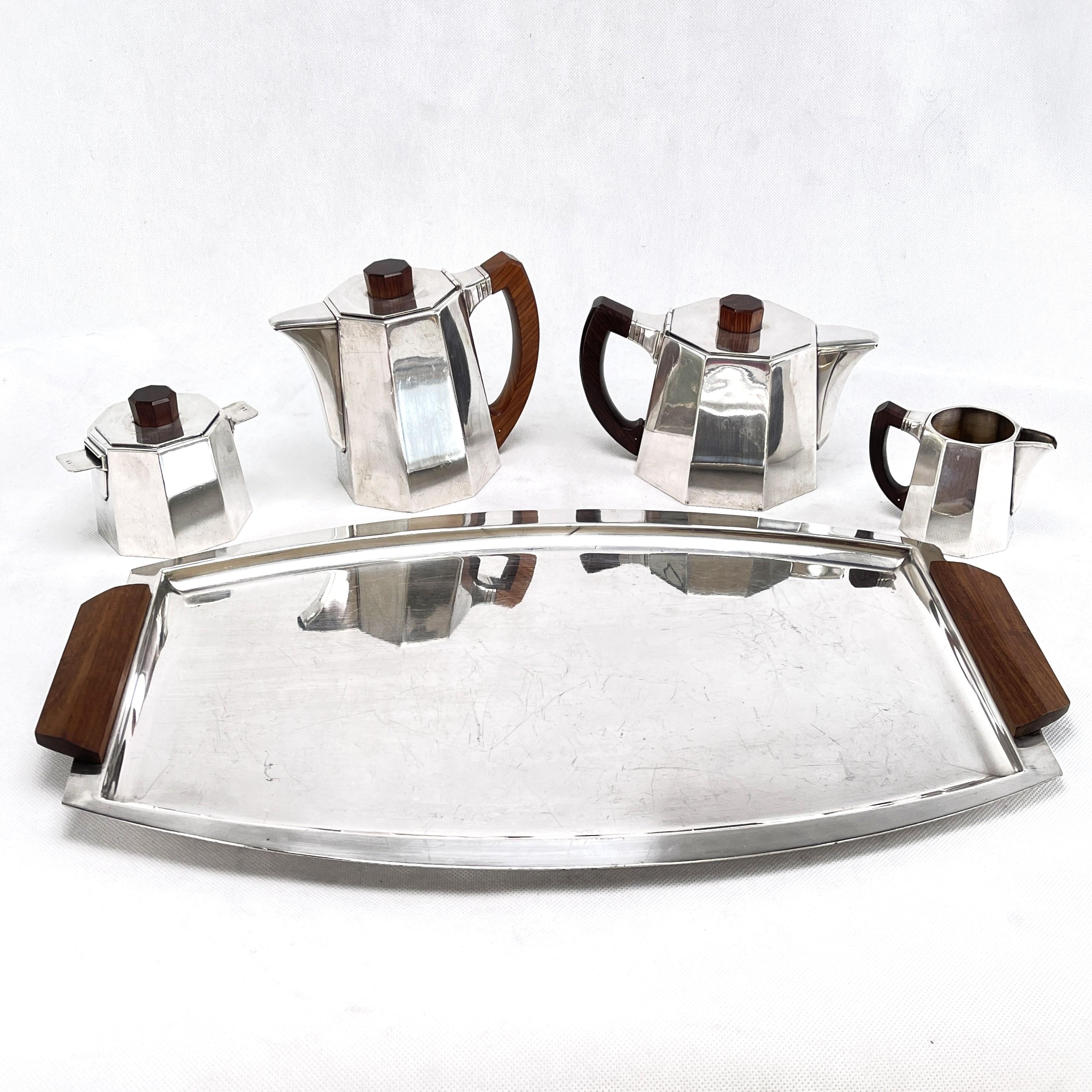 Coffee/tea set - 1930s

This coffee set from the 1930s is in the typical style of the streamline modern. It includes a coffee pot, teapot, sugar bowl, creamer and a handled tray.

The mesures only refer to the handled tray.

Further mesures:

Coffee