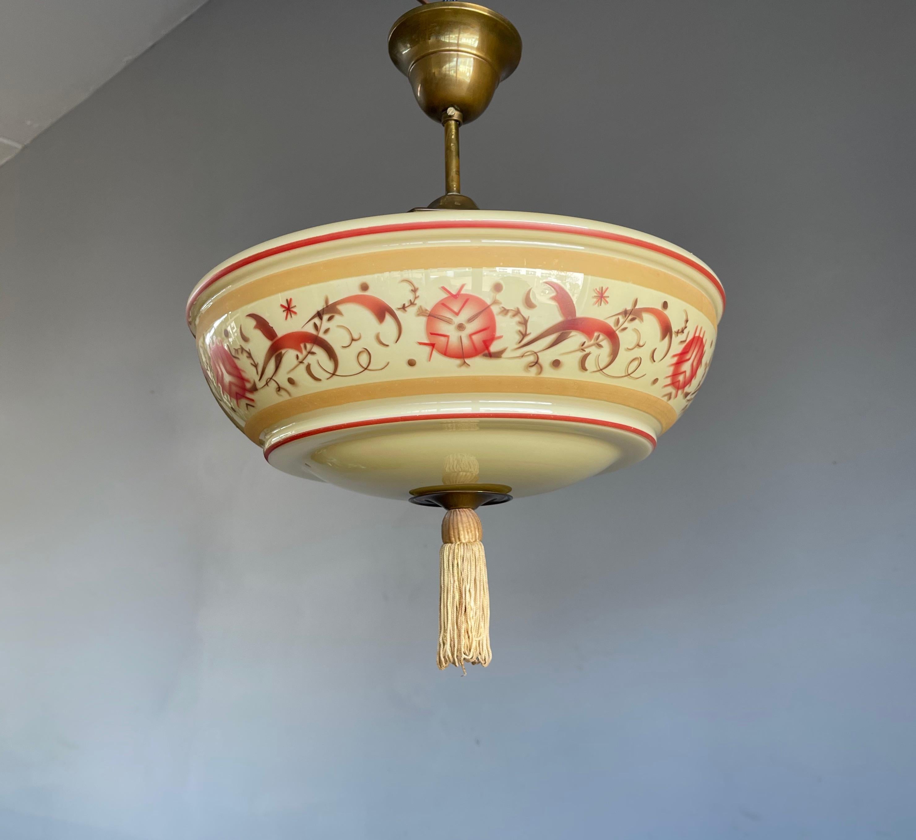 Handcrafted and finely painted, brass and glass ceiling fixture.

This rare Art Deco pendant is in excellent condition and a joy to own and look at. The hand-crafted glass shade is of a beautiful design and with the painted and organically