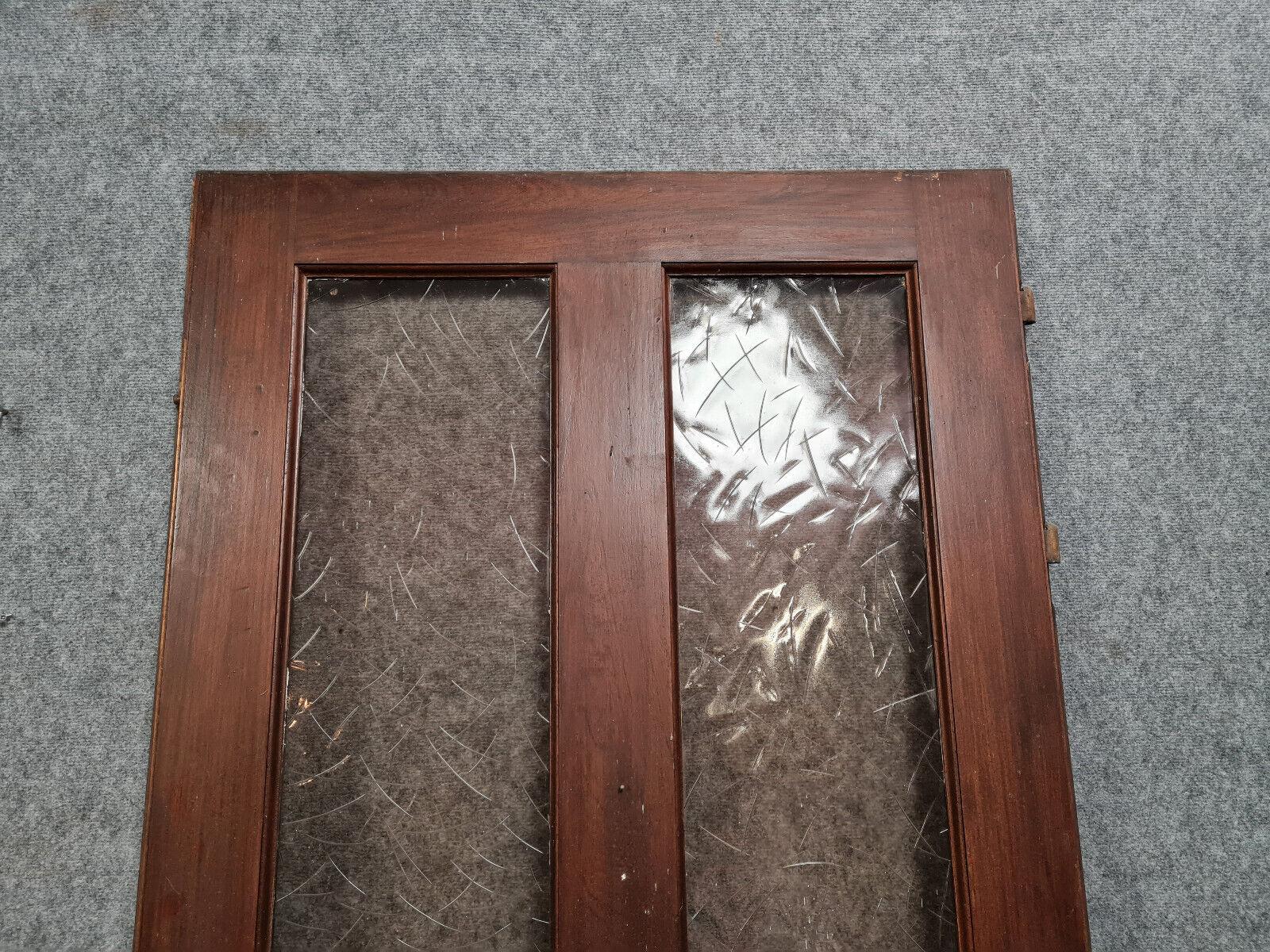 Migliora l'estetica del tuo spazio con questa affascinante porta Art Deco, realizzata in legno massiccio e risalente agli anni '30-'40 del secolo scorso. Elegata con squisiti dettagli a punta di diamante e con pannelli in vetro fumé, questa porta