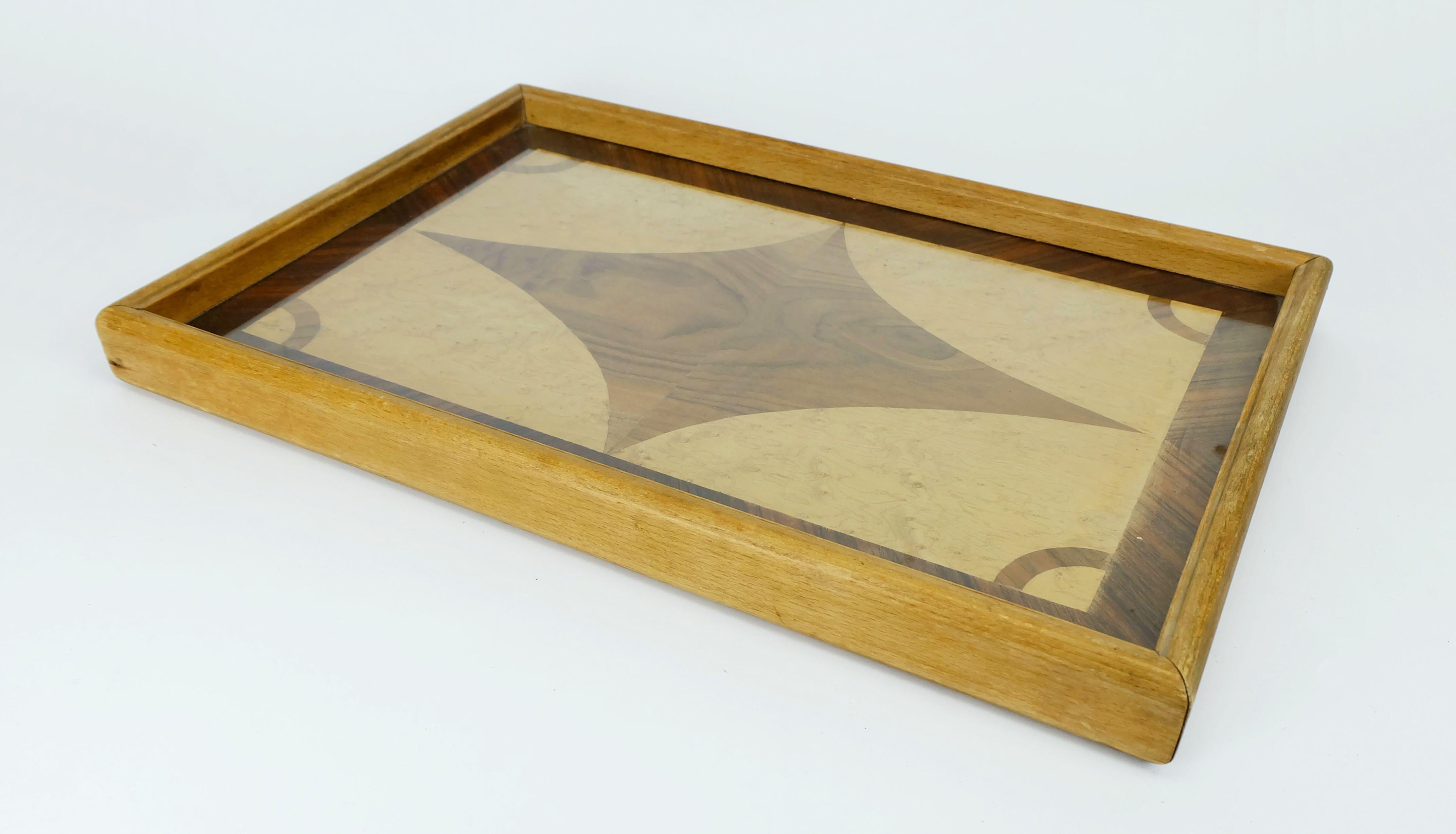 Art-Deco-Tablett mit Einlegearbeiten aus verschiedenen Holzfurnieren (Nussbaum, Vogelaugenahorn, Palisander). Der Rahmen ist aus massiver Buche gefertigt. Hergestellt in den 1920er bis 1930er Jahren. Sehr schöne Intarsienarbeit unter Glas, in