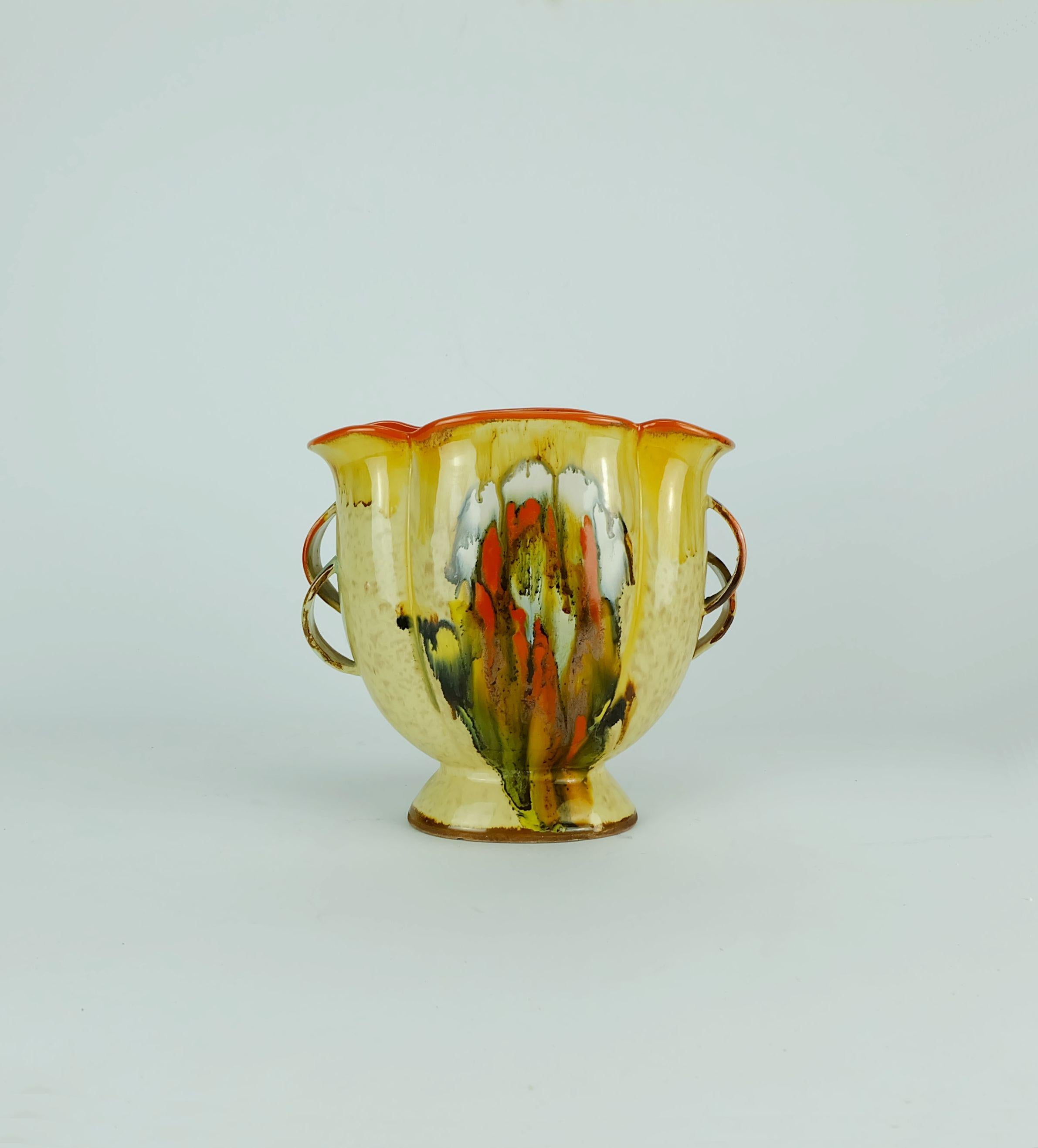 Sehr schöne Keramikvase mit doppeltem Henkel aus den 1930er Jahren mit mehrfarbiger Tropfglasur auf Beige. Hergestellt von Dümler & Breiden. Gezeichnet unten 249 V.

Abmessungen: Höhe 19,3 cm (7 1/2