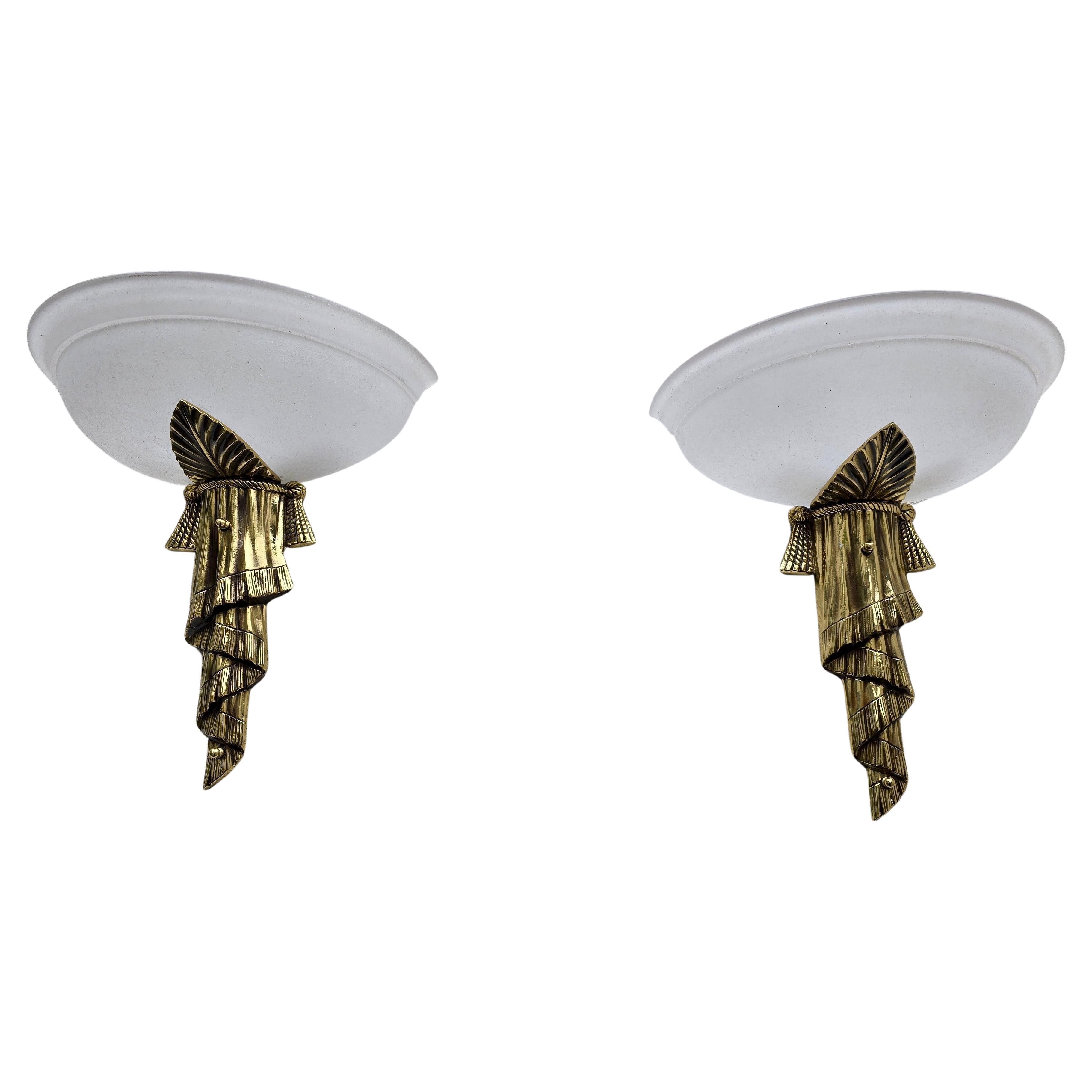 Un par de preciosos apliques italianos de estilo Art Déco de la década de 1970. Estas luces están hechas de latón de alta calidad y tienen una pantalla de cristal opalino que difunde una luz cálida y suave. El elegante diseño con líneas curvas y