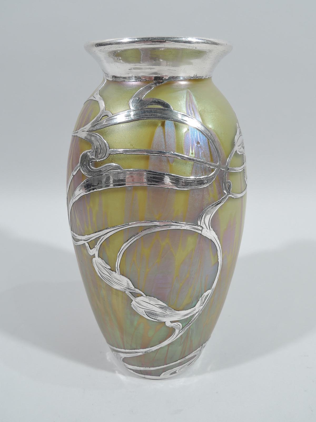 Turn-of-the-century Art Nouveau glass vase by historic Loetz with engraved silver overlay. Ovoid with flared rim. Overlay in form of loose, meandering, and whiplash tendrils with elongated flower heads. Iridescent glass in Medici pattern with