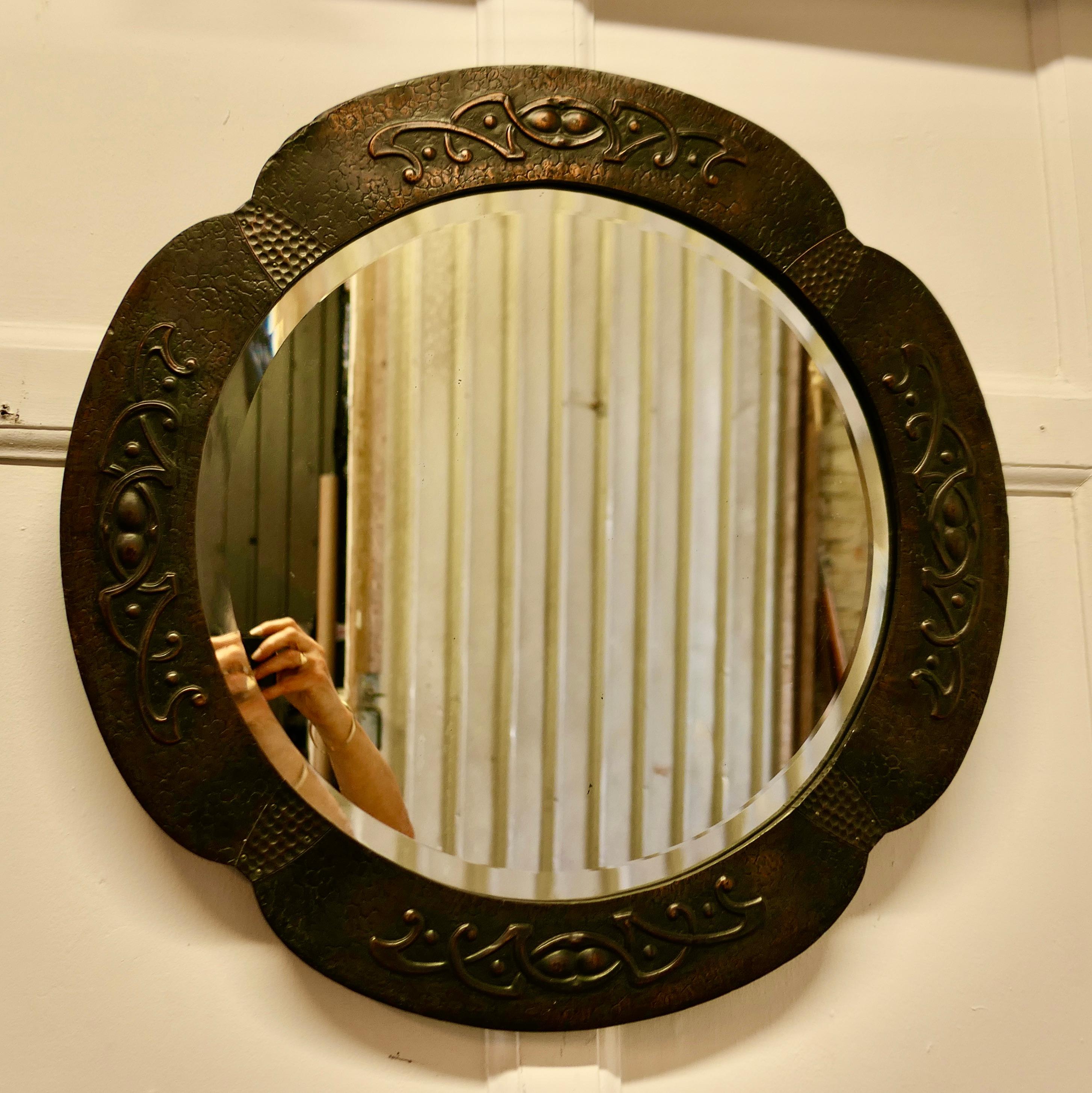 Beautiful Art Nouveau Round Copper Wall Mirror 

This is a very attractive Arts and Crafts piece, the 3” wide copper frame is hand made in beaten copper with Art Nouveau stylised designs around the edge, and the glass is the original bevelled