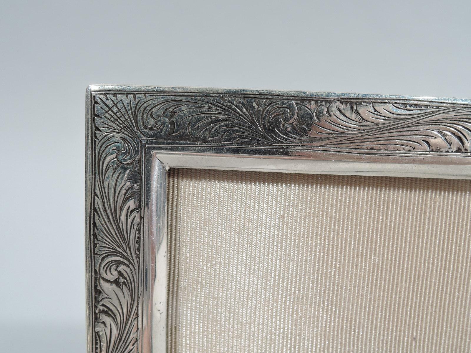 Beautiful turn-of-the-century Art Nouveau 900 silver picture frame. Two rectangular windows in rectangular surround engraved with dense and lush leaves and scrolls. With glass, silk lining, and velvet back and hinged support. For two special