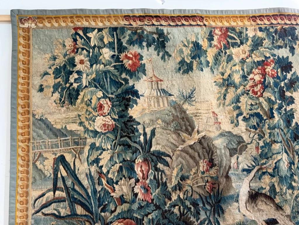 Aubusson Tapestry, Verdure “Exotique” after Jean-Baptiste Pillement, horizontal, having pagodas , birds, and columns of flowers.  The border in the form of a frame.  Singed at the center of  the base 