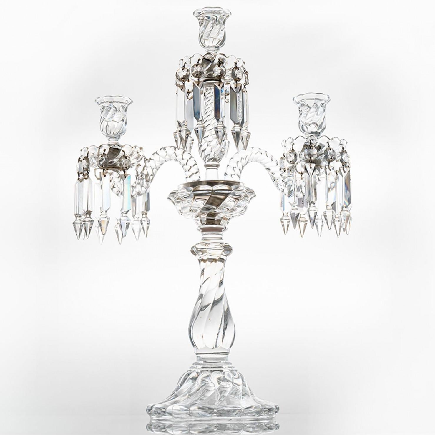 Obra maestra de cristal de bellas proporciones, este portavelas cristaliza el extraordinario saber hacer de los artesanos de Baccarat. Los diferentes cortes del cristal producen un efecto visual mágico.

Candelabro de tres luces, con dos brazos