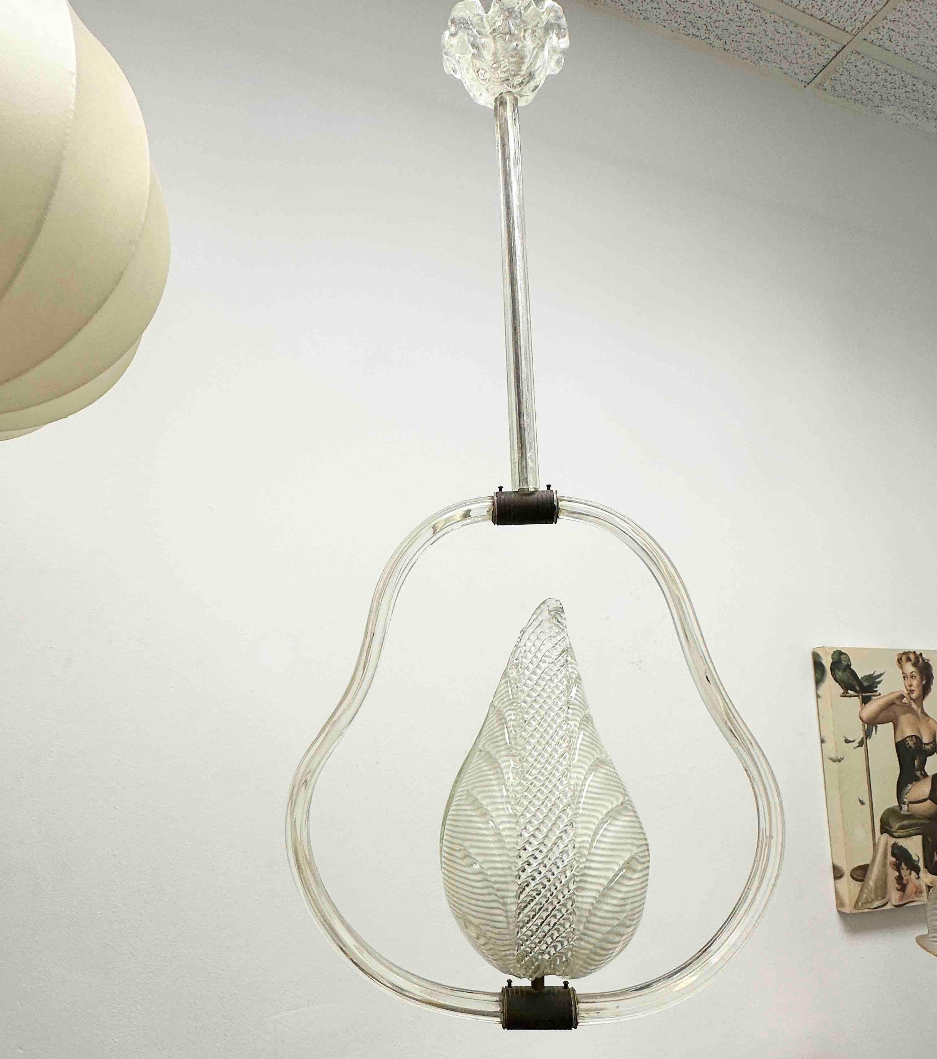 A petite hand blown Italian Barovier & Toso pendant light with glass covered brass fittings. Clear ribbed glass elements. The Fixture requires one European E27 / 110 Volt Edison bulb, up to 60 watts. A nice addition to any room. Found at an Estate