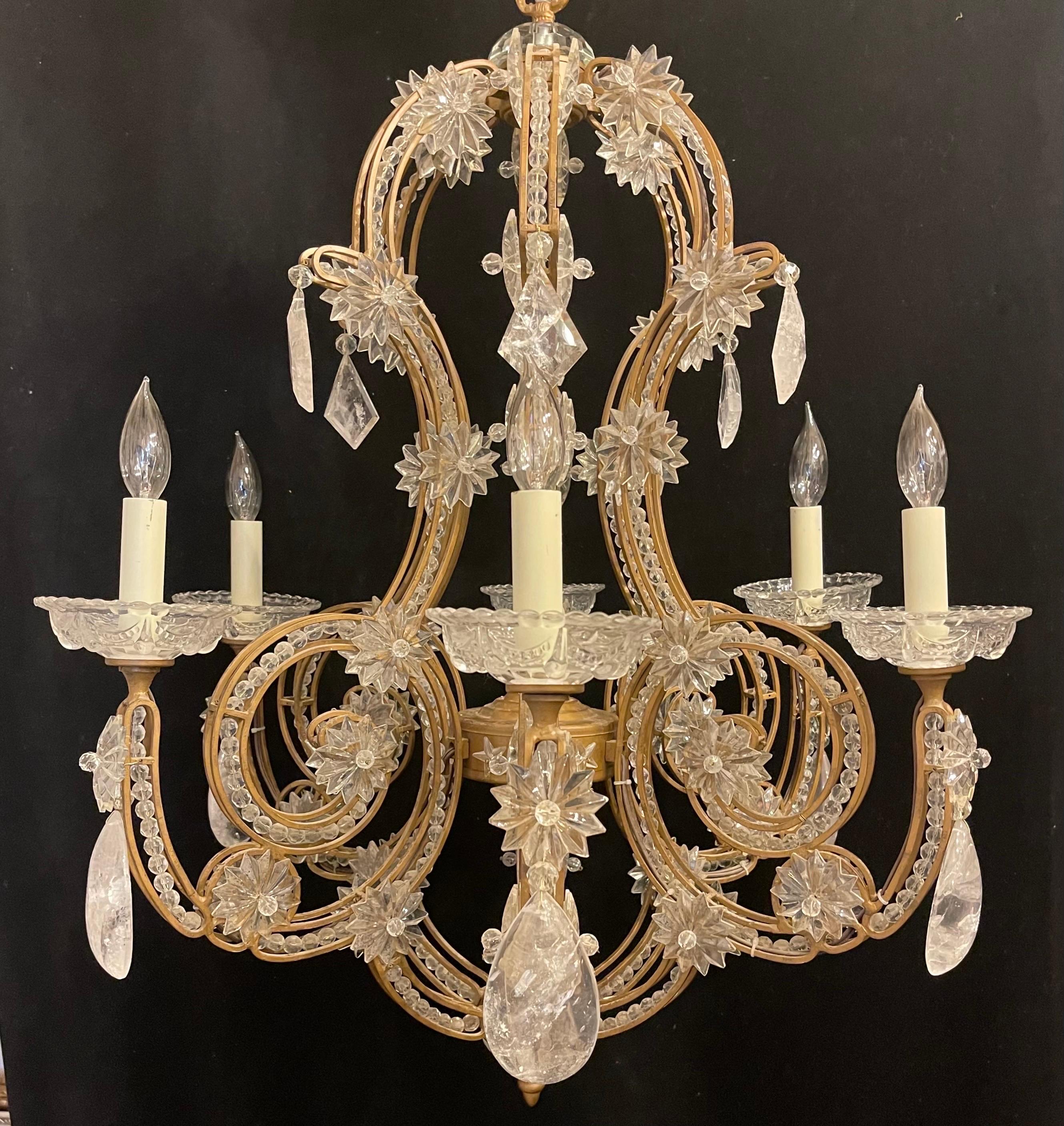 A wonderful crystal beaded bird cage chandelier dressed with rock crystals in the manner of: Vaughan, Maison Baguès & Jansen with a gold gilt frame this chandelier has 6 candelabra lights leading to beautiful crystal swag bobeches.