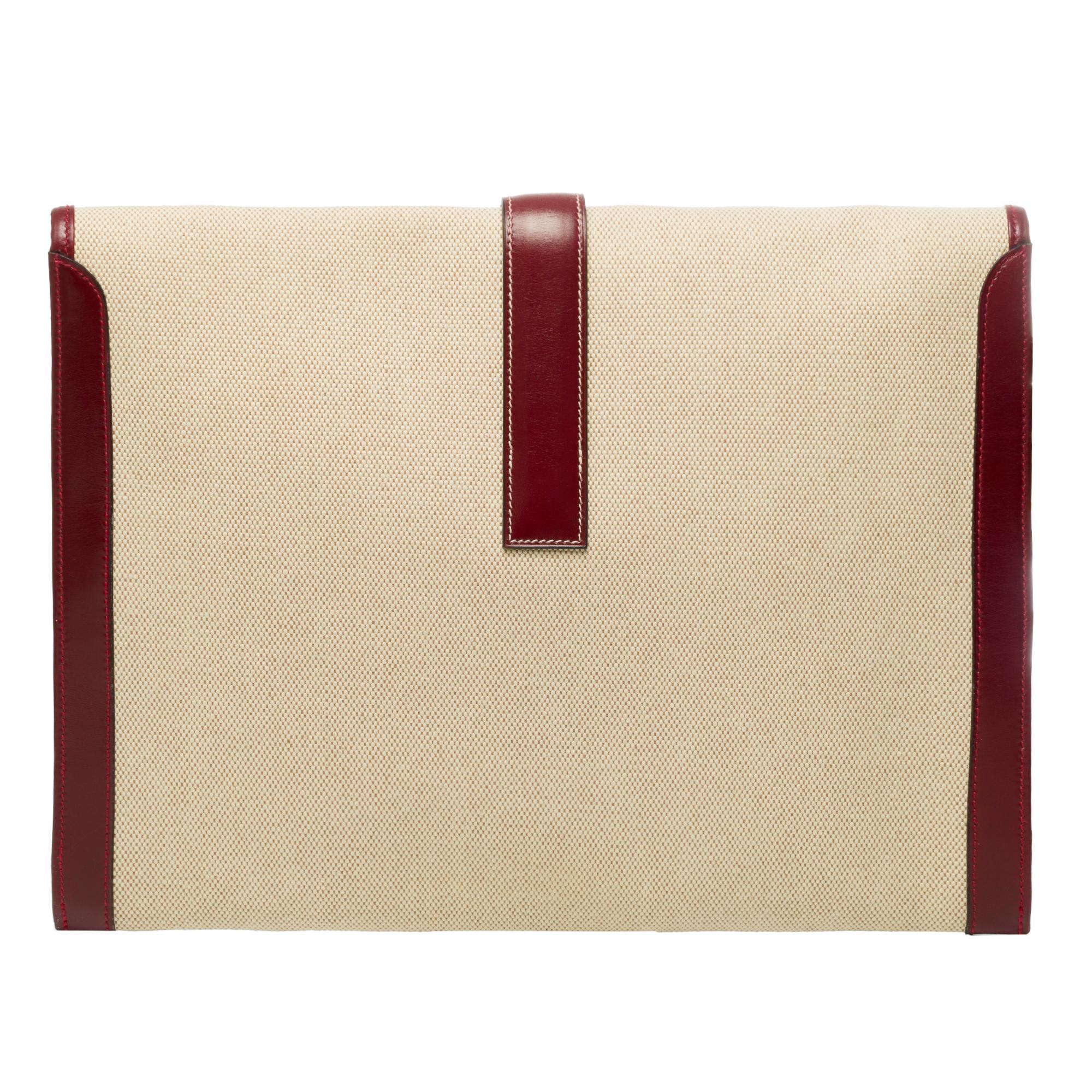 Beautiful Hermes Jige pouch large model bi-material in beige canvas and burgundy box leather, white stitching, handheld.

H closure on flap.
Lining in beige canvas.
Signature: 