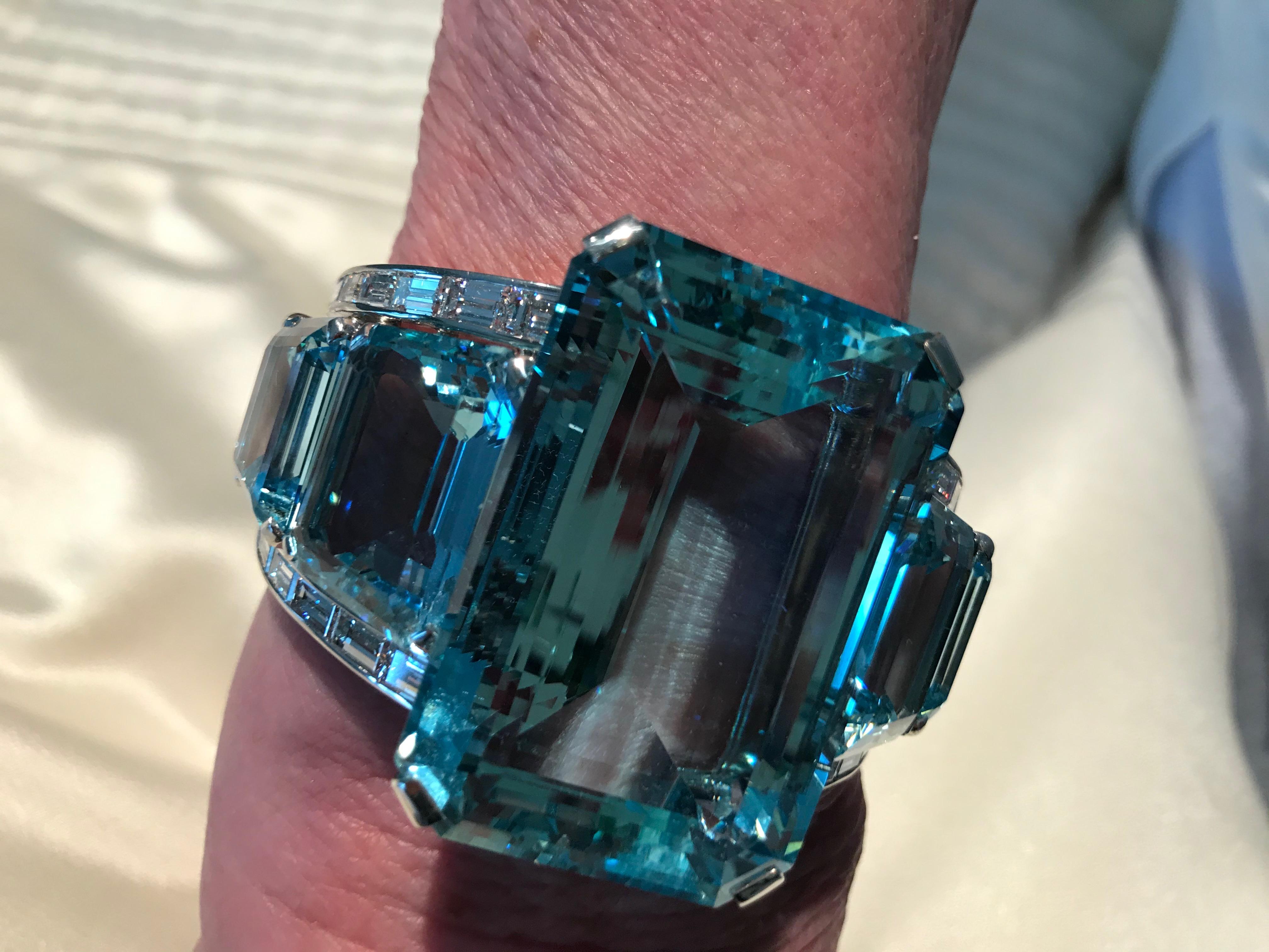 This one of a kind impressive bangle is set in platinum. The center features one large emerald cut Aquamarine weighing 181cts and is flanked by four fancy cut Aquamarine's weighing approximately 60cts in total. The, Aquamarine's are accented by