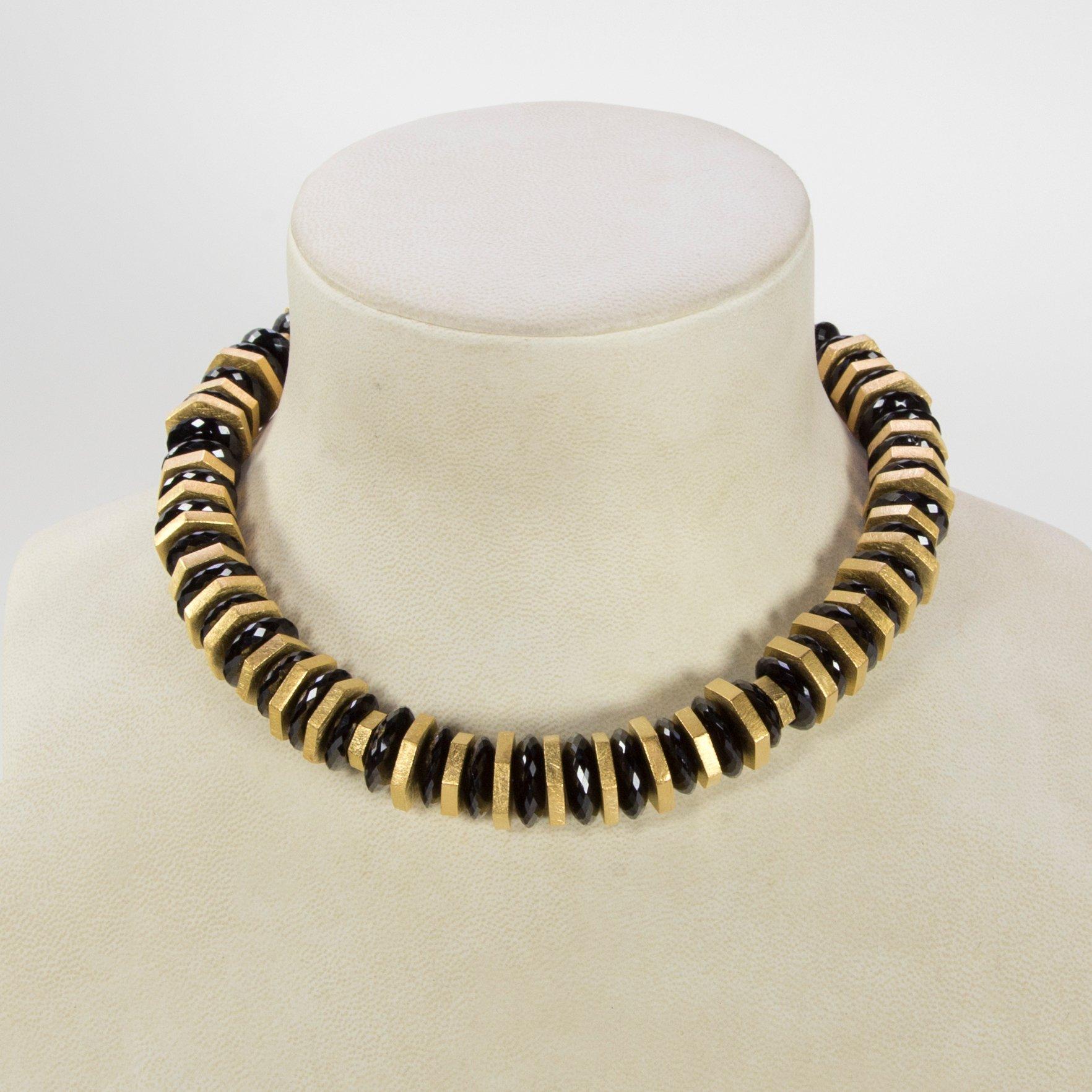 Magnifiche perle rotonde di Spinello Nero di alta qualità con taglio sfaccettato, intervallate da dischi d'argento placcati in oro e trattenute da un'esclusiva chiusura in argento dorato, conferiscono a questa semplice collana un fascino drammatico.