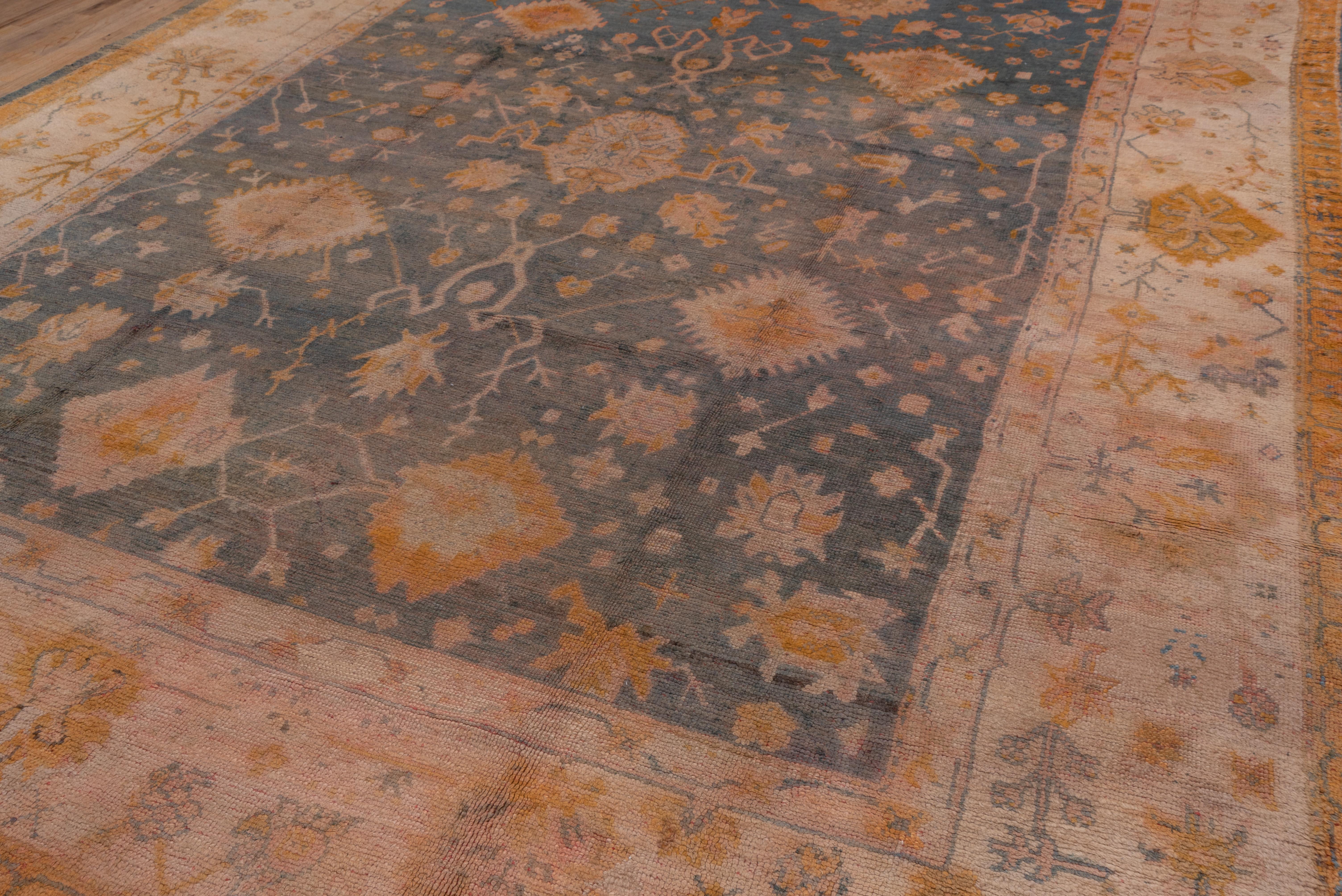 In a general Persian Heriz semi-geometric style, the Turkey red field of this western Anatolian workshop carpet displays a serrated, pendanted and lobed light blue medallion with an octagon center and goldenrod corners sprouting small flowers. The