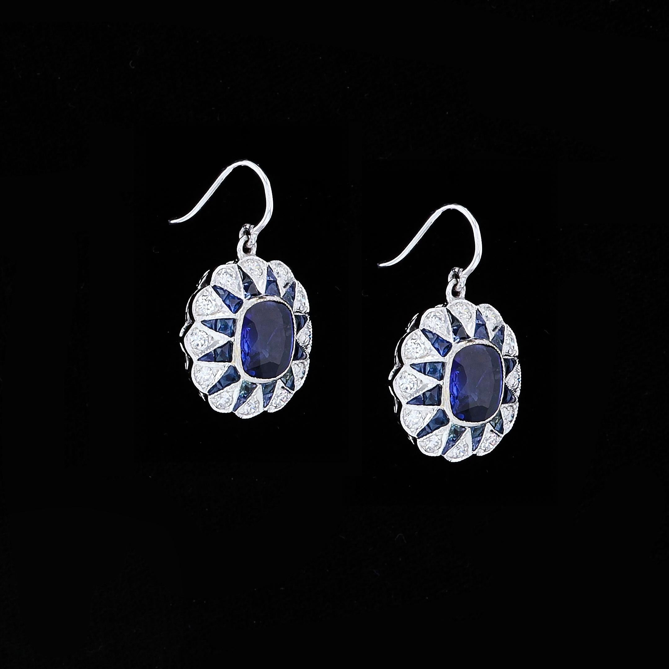 Crafted in 18K White Gold these drop style earrings feature 5.44ct Sapphires 1.21ct Round Cut Diamonds . A stunning pair of earrings, they measure 23mm by 15.5mm and weigh 5.7 grams.

