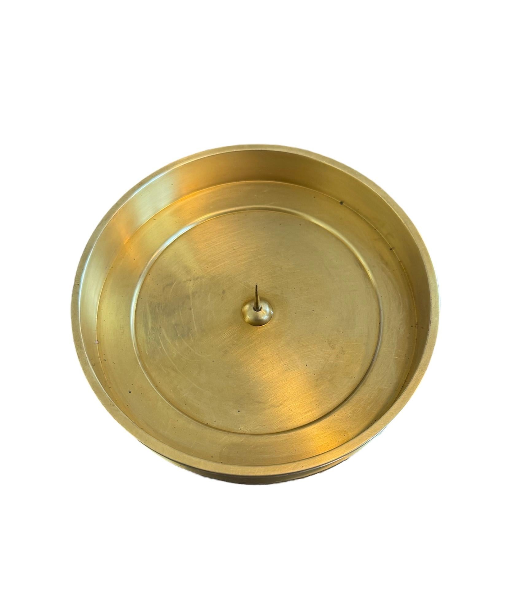 Elevate your home decor with this elegant brass candle holder dish, a beautiful accessory that brings a touch of sophistication to any setting. Designed to hold a single pillar candle, it casts a warm, inviting glow, perfect for creating an intimate