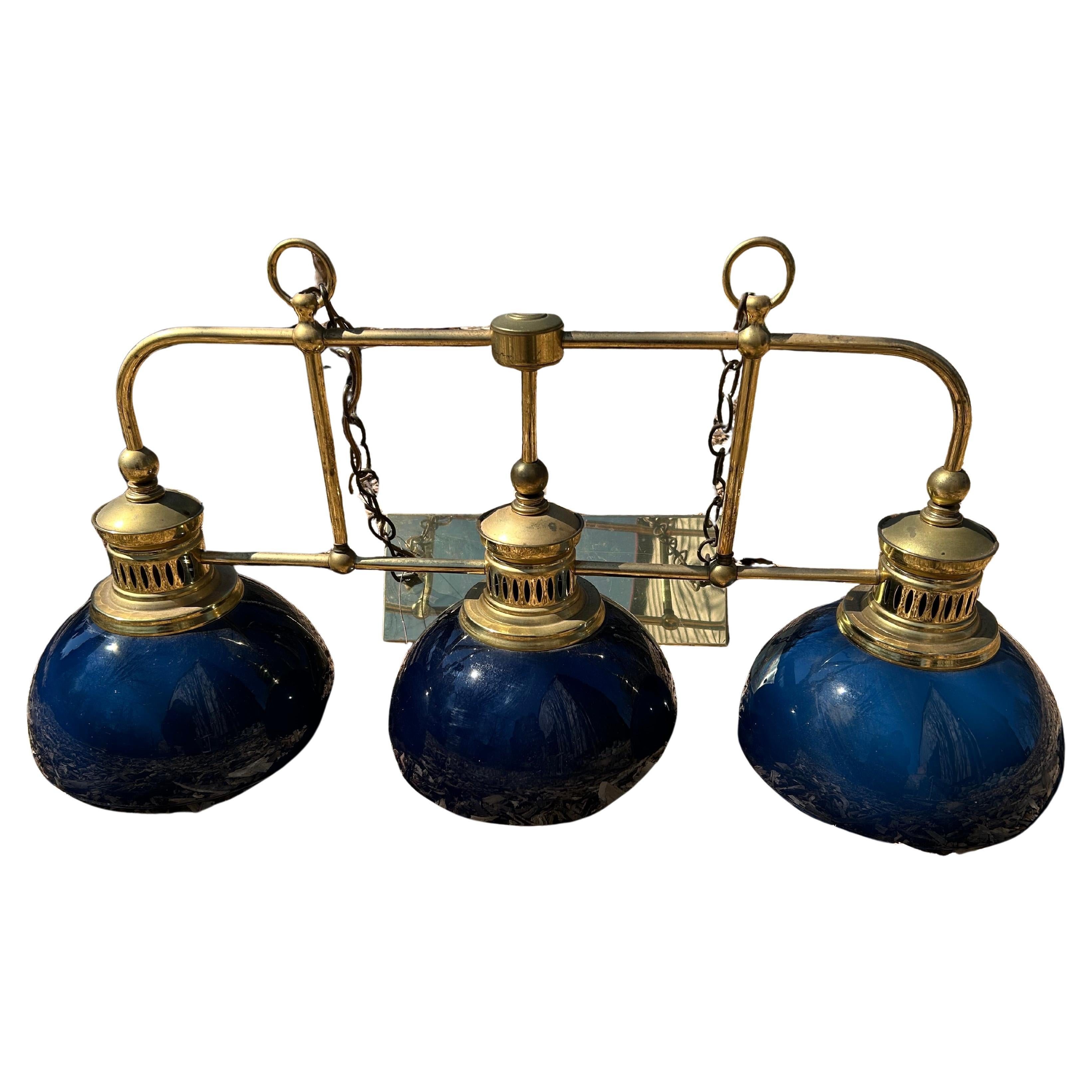 Impressive 3 light brass and midnight blue art glass chandelier, perfect for over a kitchen island or pool table. Interior of glass shades are white.
Each shade is 11” diameter.
Brass rectangular ceiling cap is 14.5 x 5.75