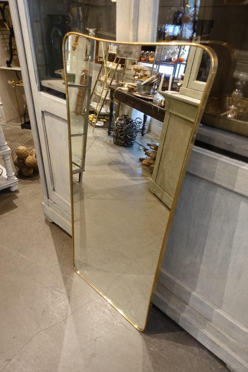 Slim and tall beautiful Italian brass midcentury mirror, with a lovely curved frame. Style wise attributed to the renowned Gio Ponti mirrors. Original glass and beautiful patina in the brass.