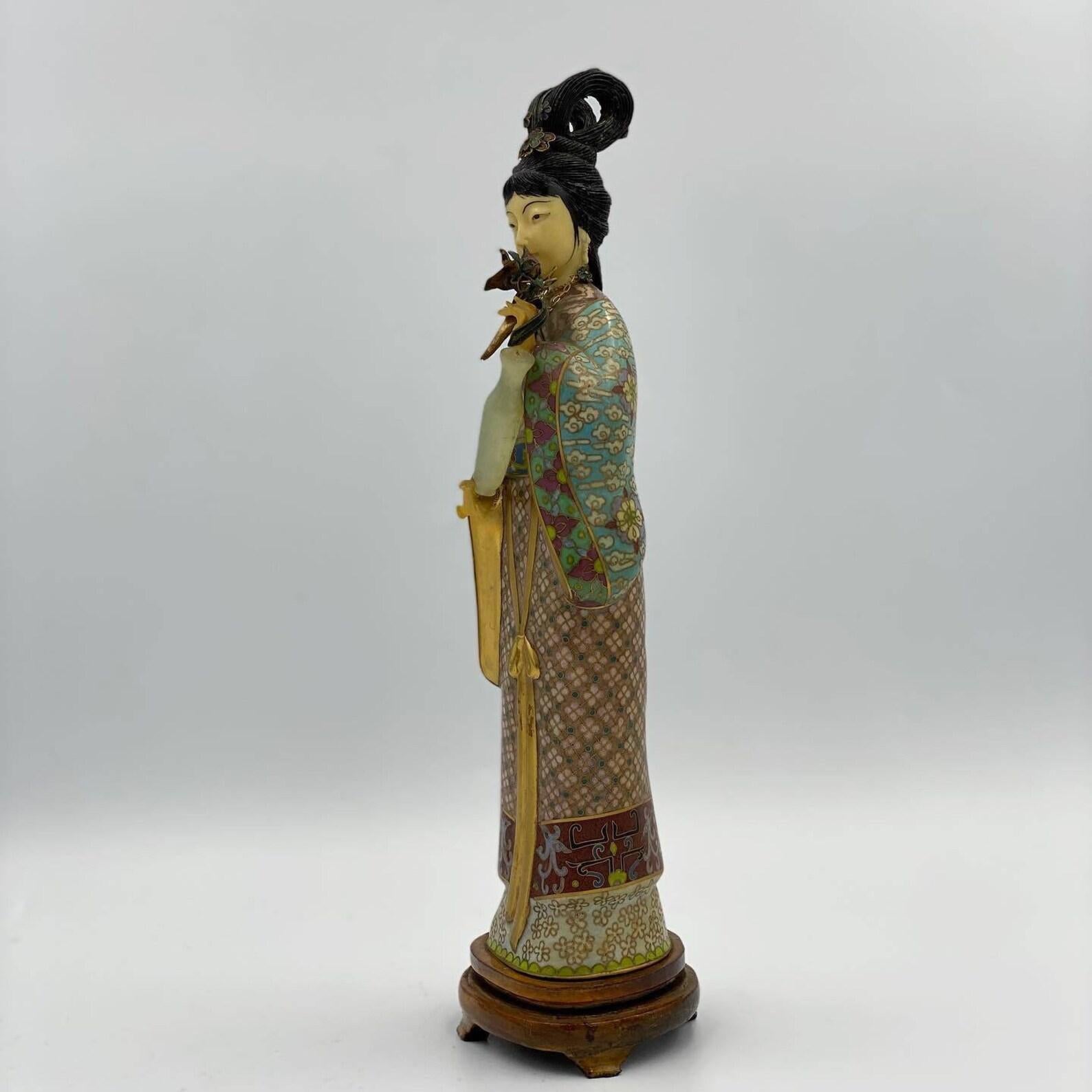  Stupéfiante statuette cloisonnée vintage  Geisha avec fleurs et cruche en jade réalisée selon la technique unique du cloisonné. 

 Sa robe kimono est magnifiquement conçue. Le look est complété par un collier et les cheveux sont décorés de fleurs.