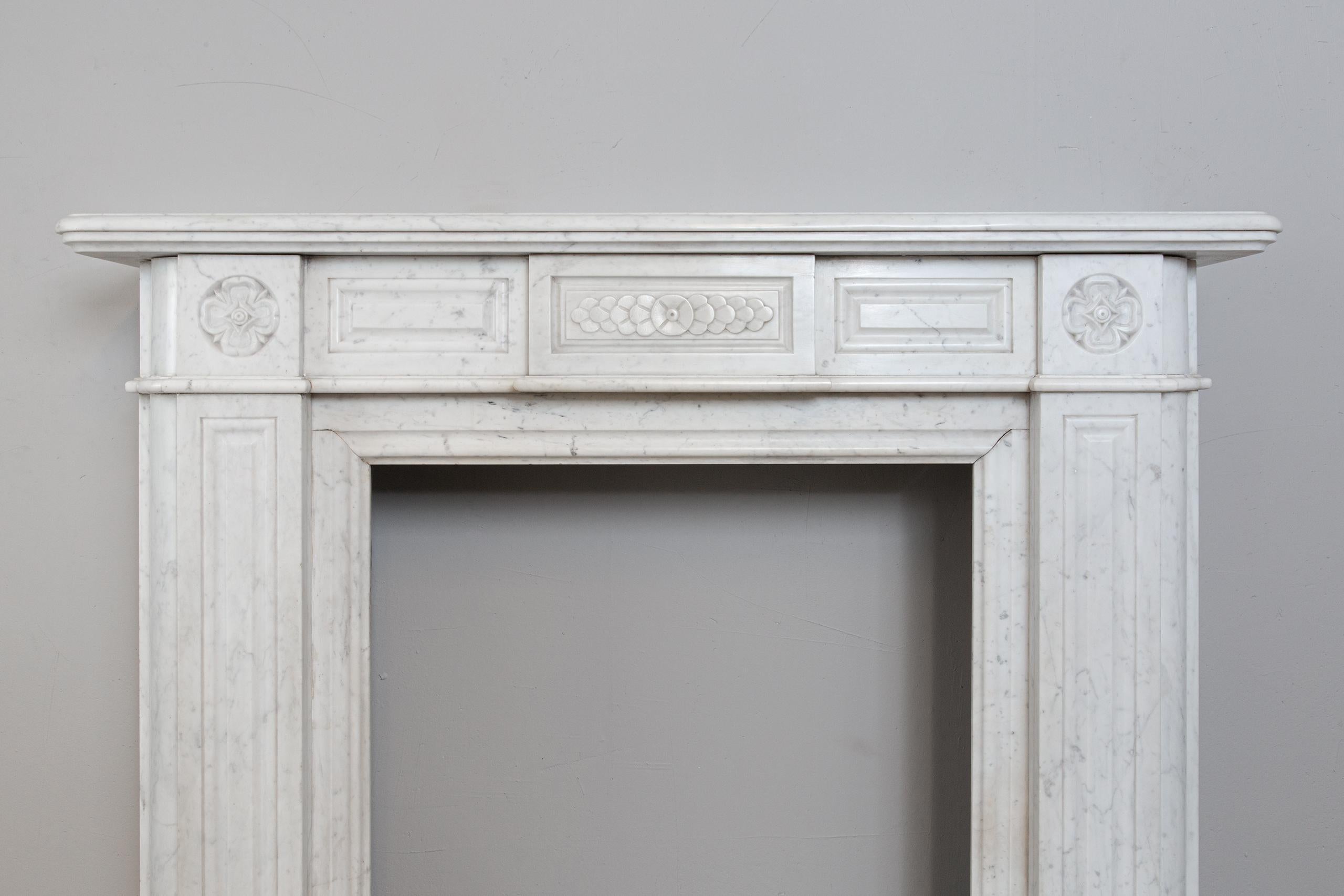 This fireplace, executed in the beautiful clear white Carrara marble, exudes luxury. The round corners that continue from the plinth to the top give this fireplace its elegant appearance. The subtly elaborated legs with flowers on the top. The