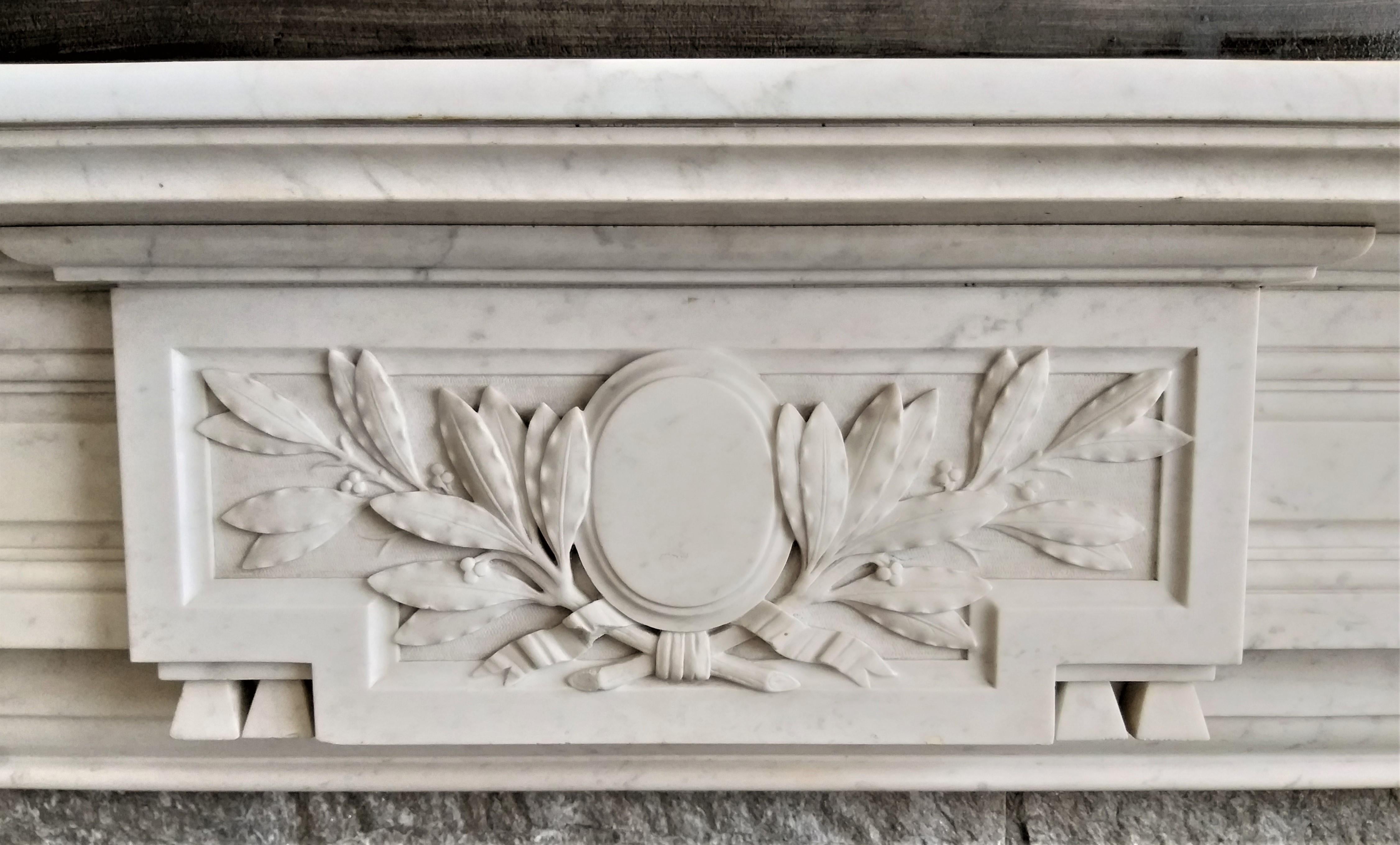 Strongly build fireplace, made out of Carrara marble. The tablet is with rounded corners and extra profiled fronts. The frieze and top-corners are nicely sculptured. It jambs are decorated with flutes and small asparagus-heads. This antique