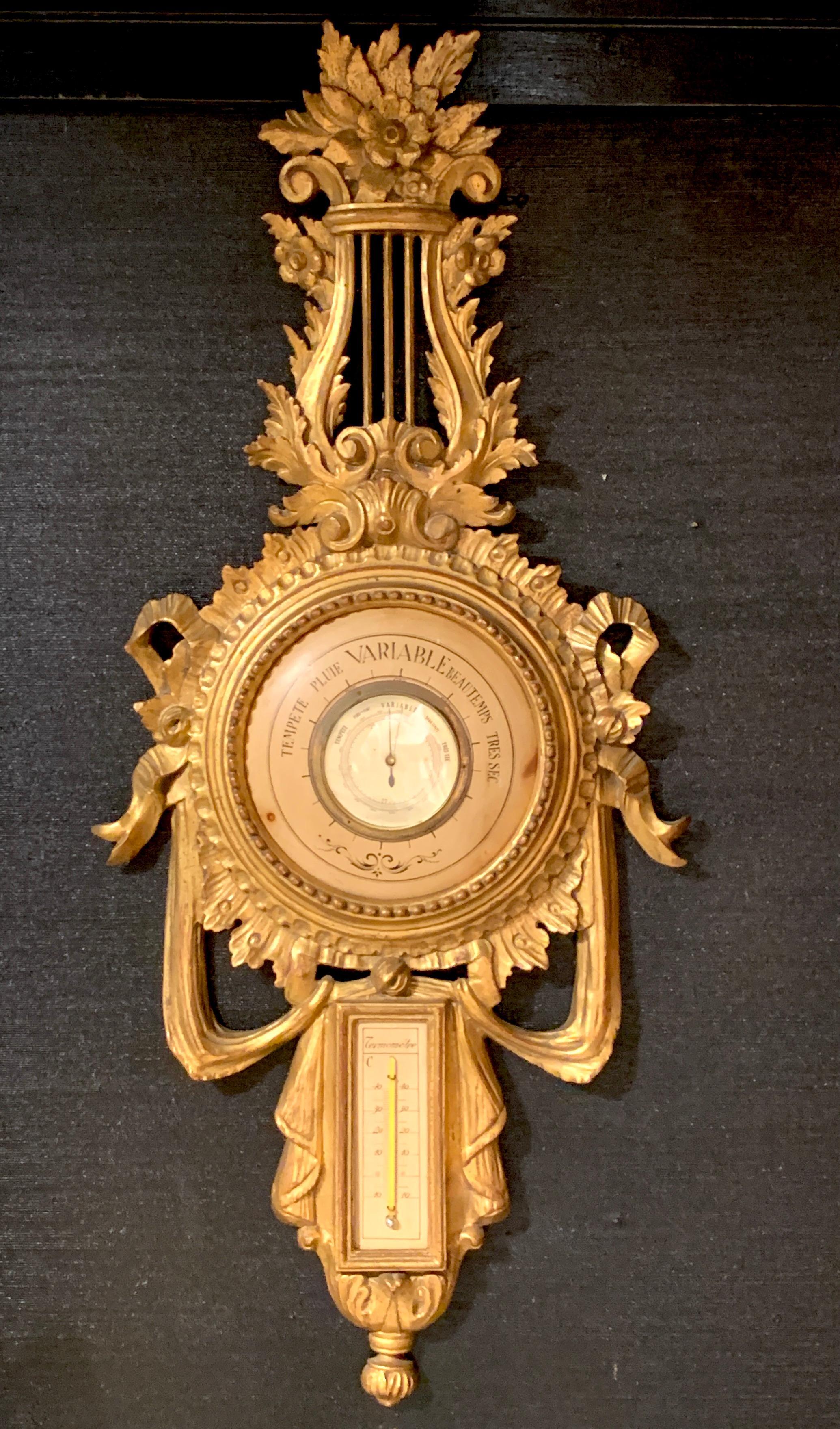 Beautiful carved giltwood Louis XVI style Lyre Barometer, with center dial with French inscriptions, the lower part fitted with glass thermometer.