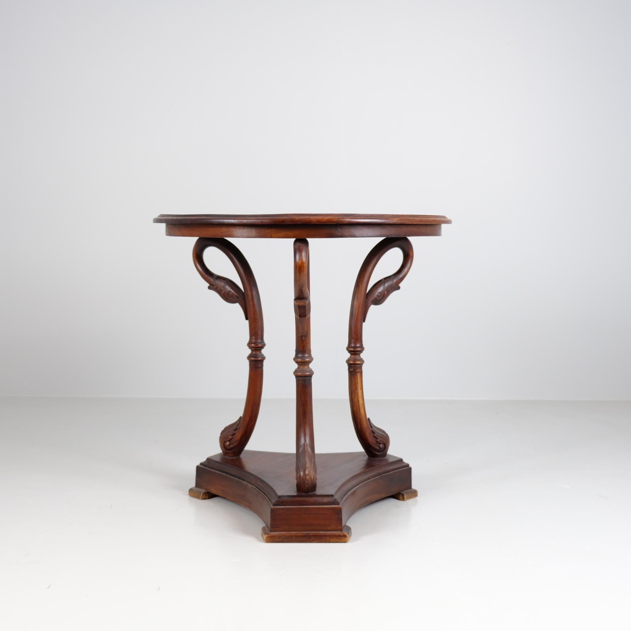 Une belle table d'appoint/centrale avec un plateau rond et trois têtes de cygnes servant de support. La table date du milieu de la deuxième moitié du 20e siècle et est de style néoclassique régence. Parfait pour les entrées avec un vase ou une