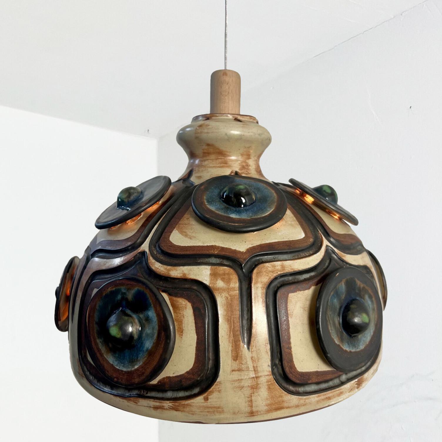 An exceptional hanging lamp with an unusual shape, made with rich colored ceramic,  manufactured in the 1970s in Denmark.

With beautiful fragile steel cable and wooden details. Hanging on a steel cable, the ceramic lamp is a real piece of art